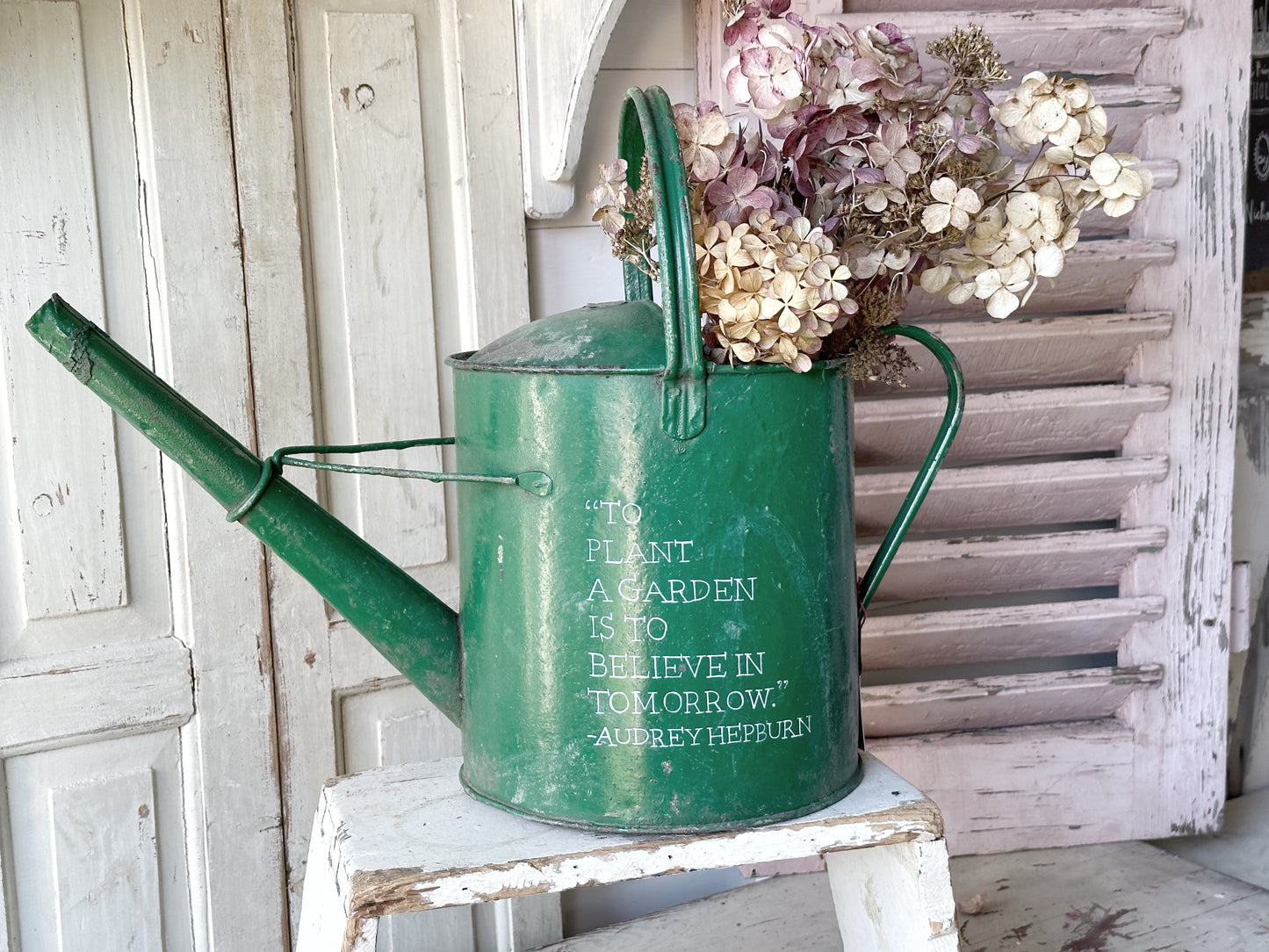 A lovely vintage galvanised watering can painted in a green coloured paint