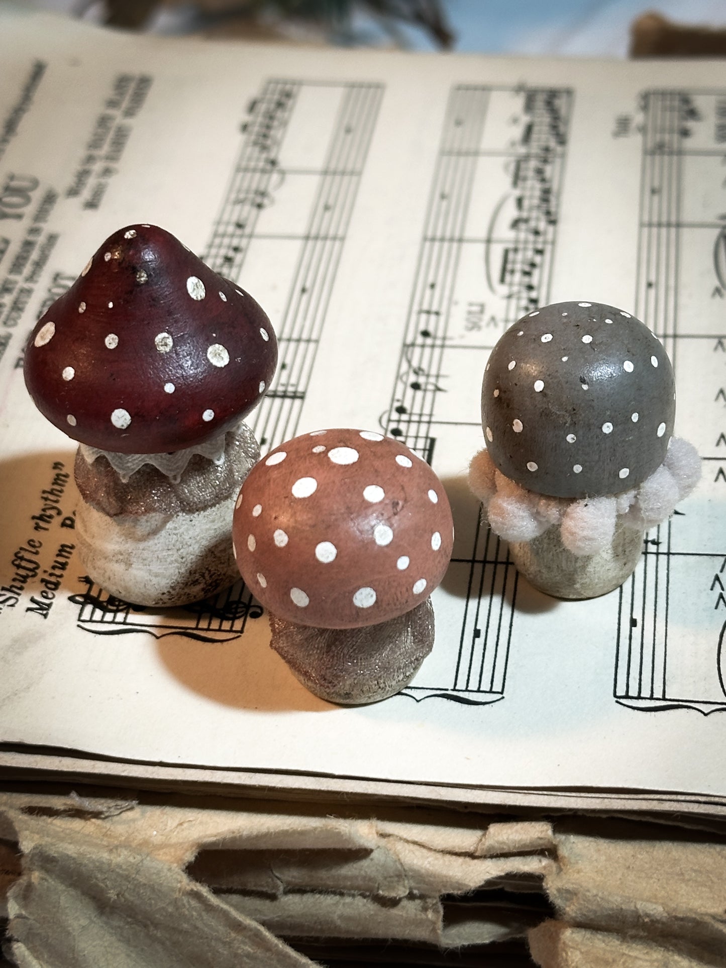 A set of three wooden hand painted and trimmed Christmas village toadstools