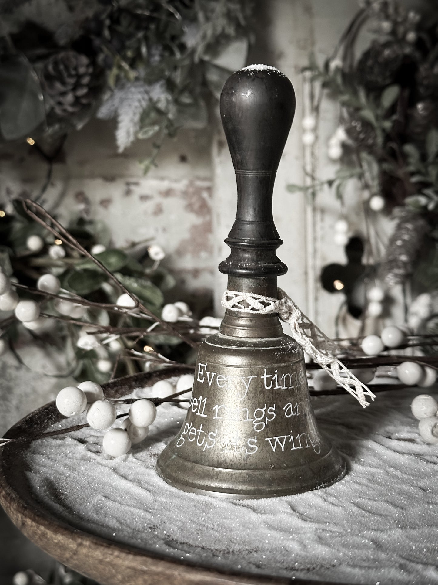 A vintage brass hand held bell with a hand painted quote
