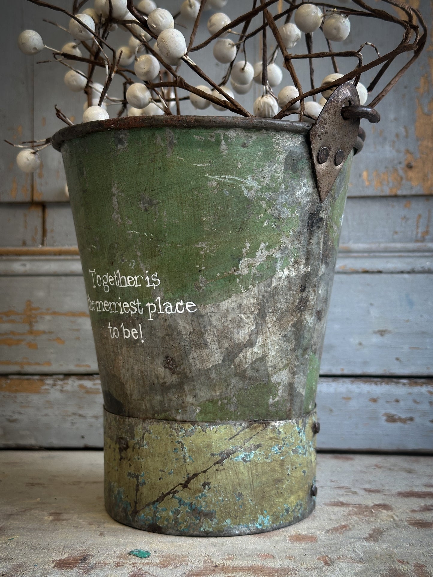 A Recycled Metal Mini Christmas Tree Bucket With A Hand Painted Quote