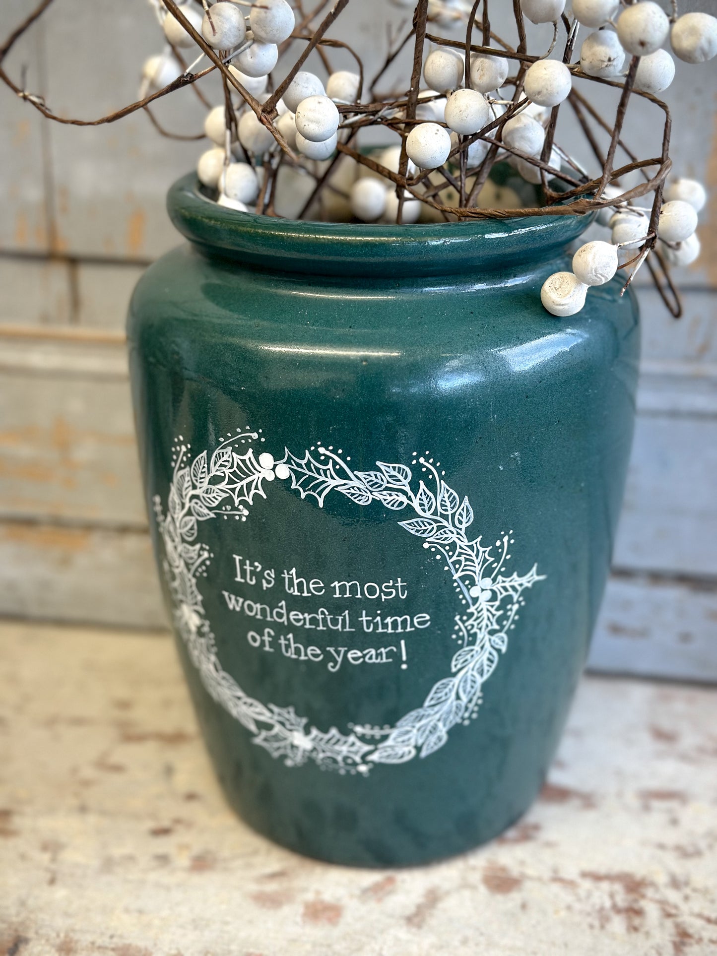 A large Emerald Green Antique Creamery Vase Bottle with a Hand Painted Wreath and Christmas Quote