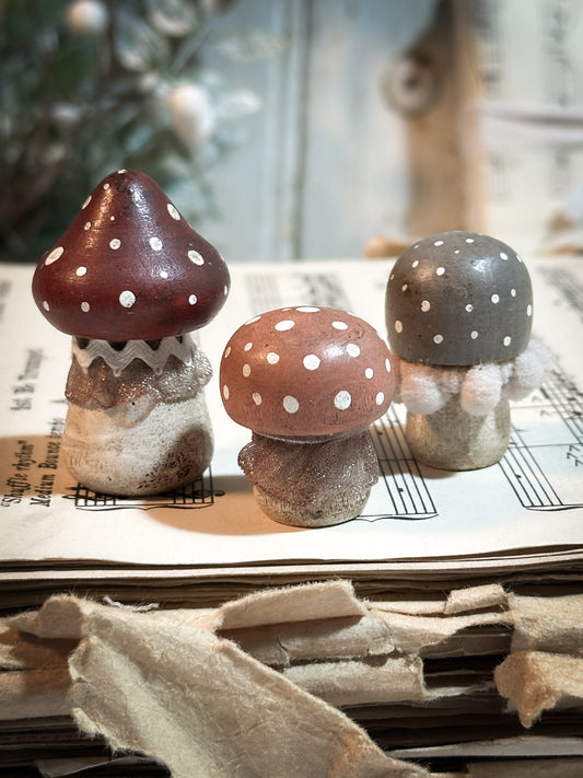 A set of three wooden hand painted and trimmed Christmas village toadstools