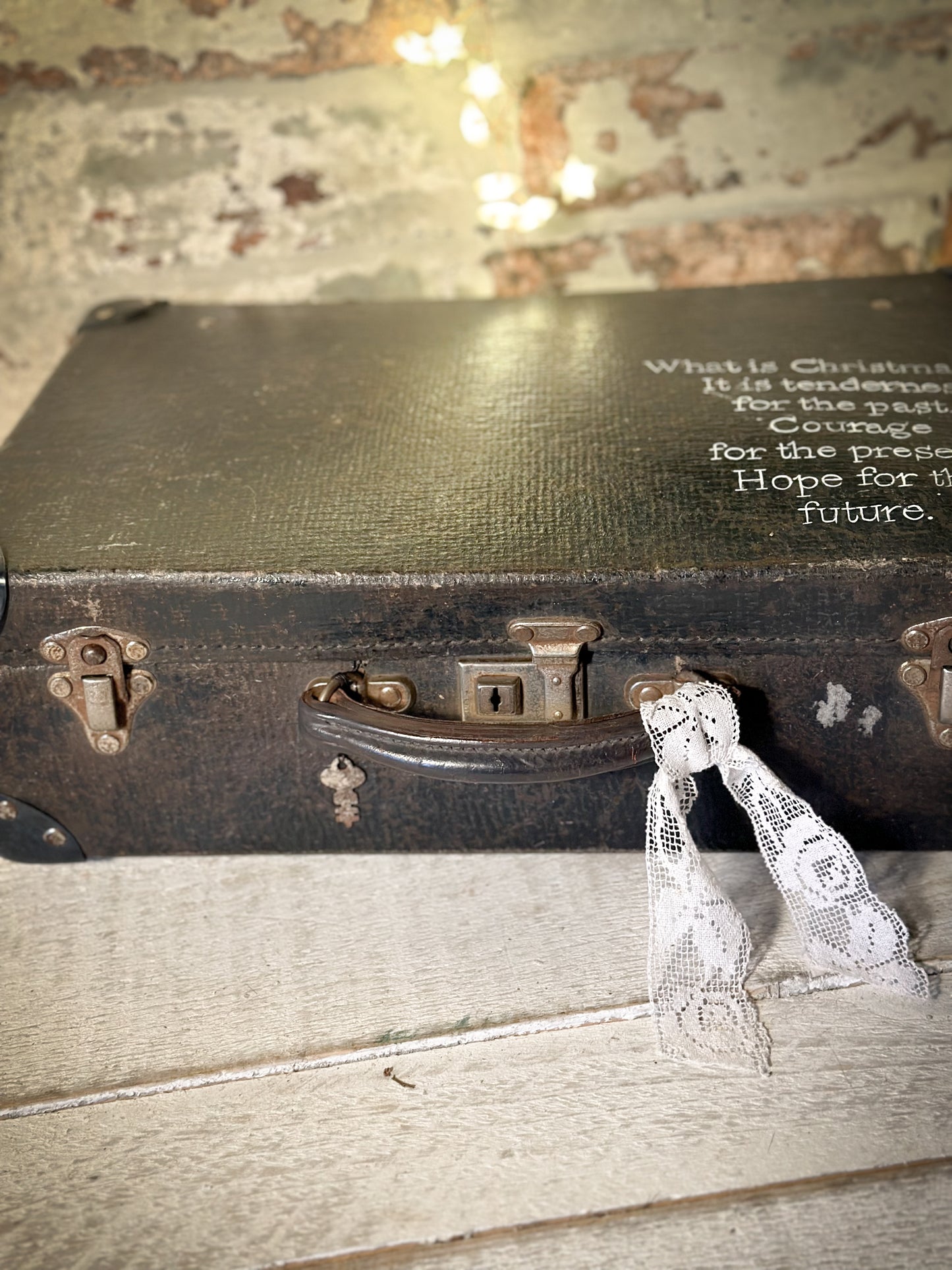 A gorgeous vintage suitcase with a hand painted quote for storing Christmas decorations