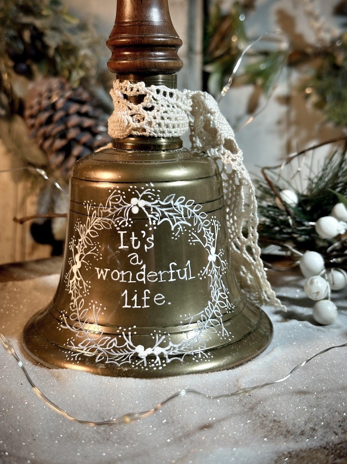 A vintage brass hand held bell with a hand painted quote