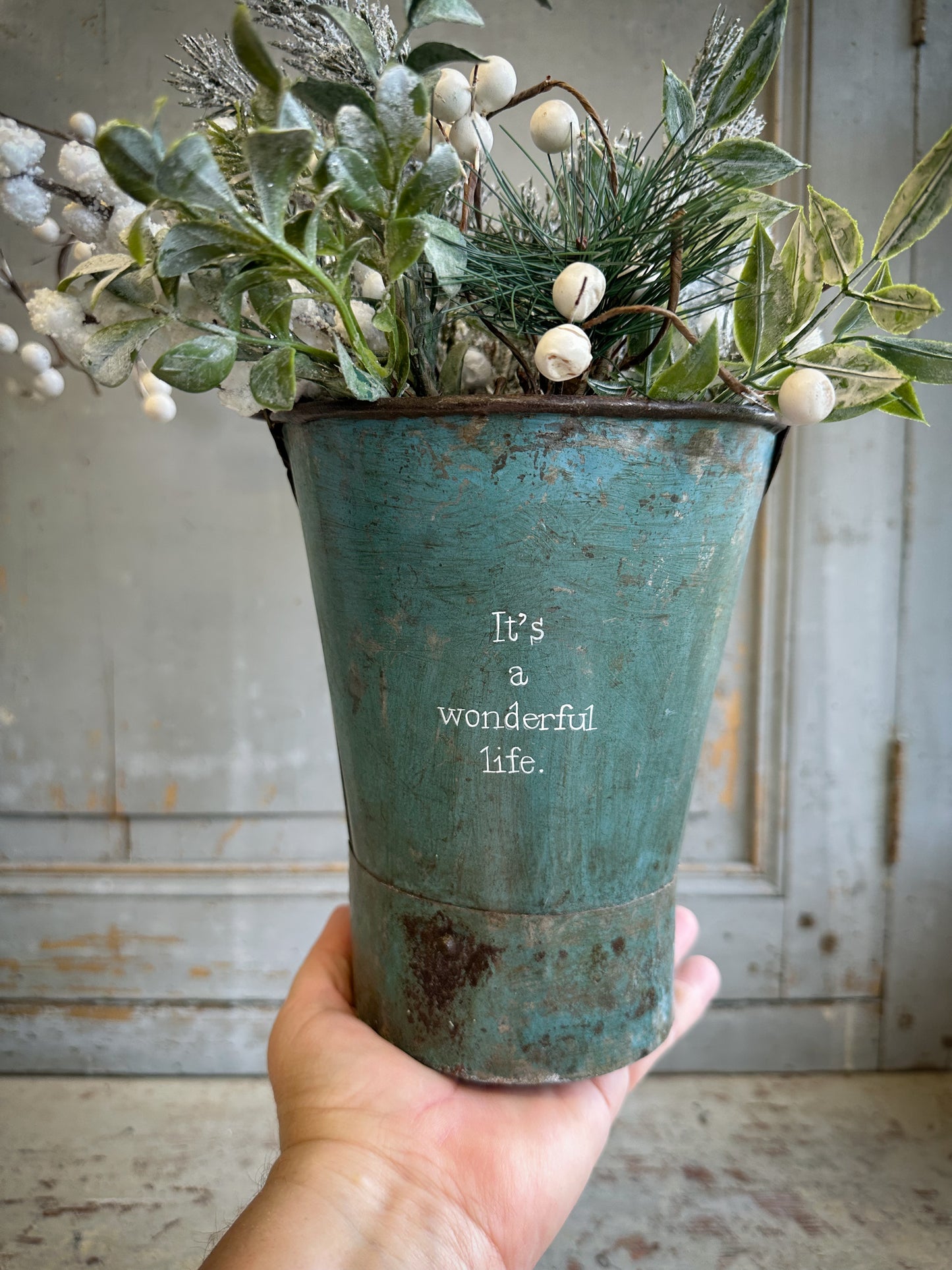 A Recycled Metal Mini Christmas Tree Bucket With A Hand Painted Quote