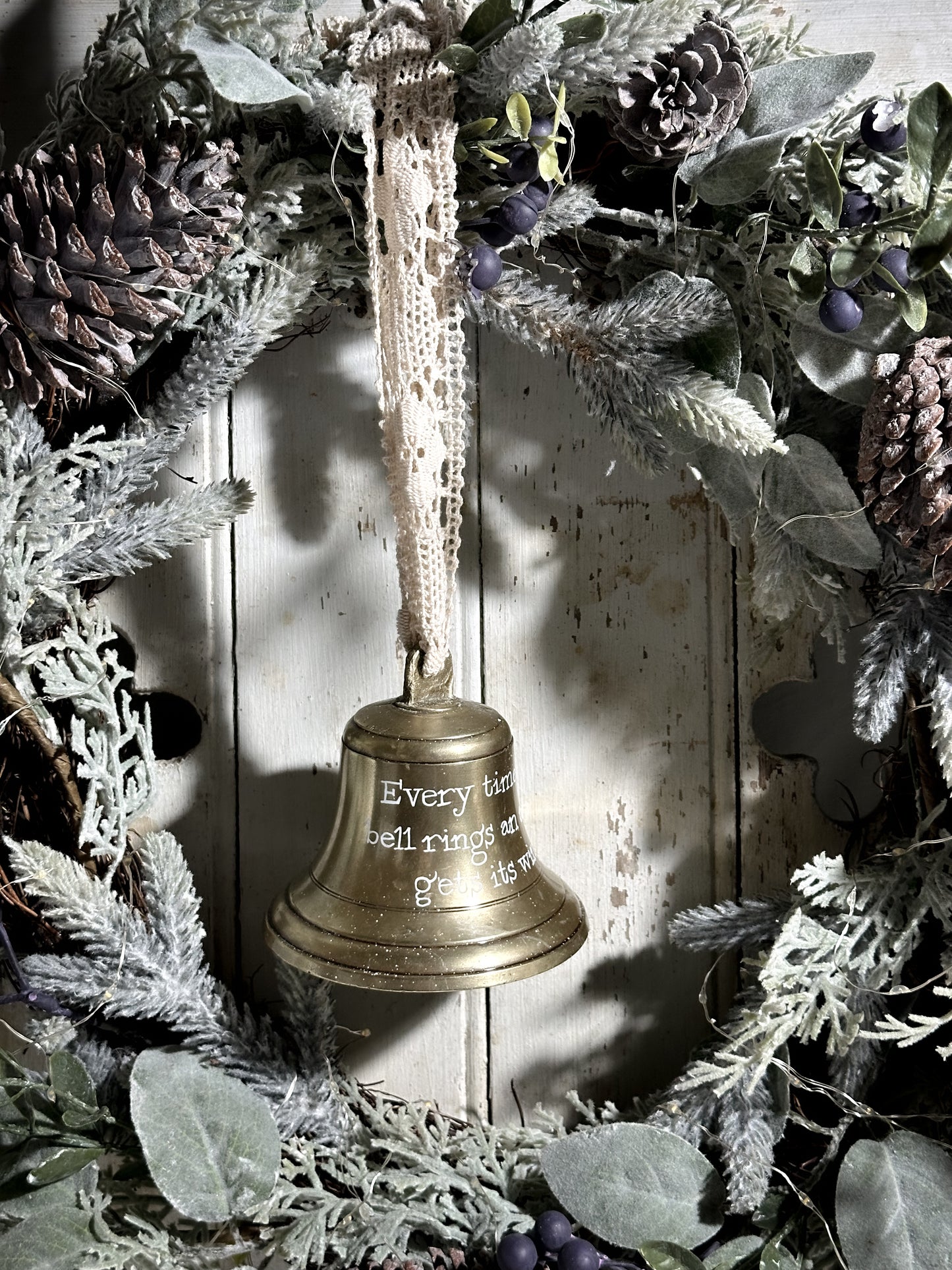 A vintage brass bell with a hand painted quote