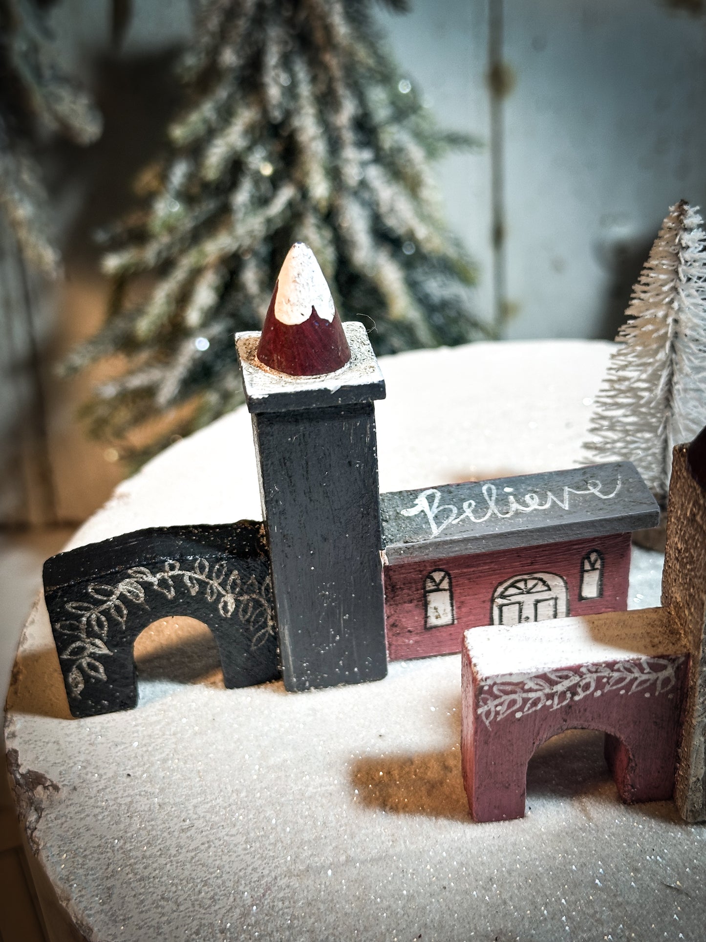 A pretty vintage German Erzgebirge Putz wooden village house painted with a Christmas quote