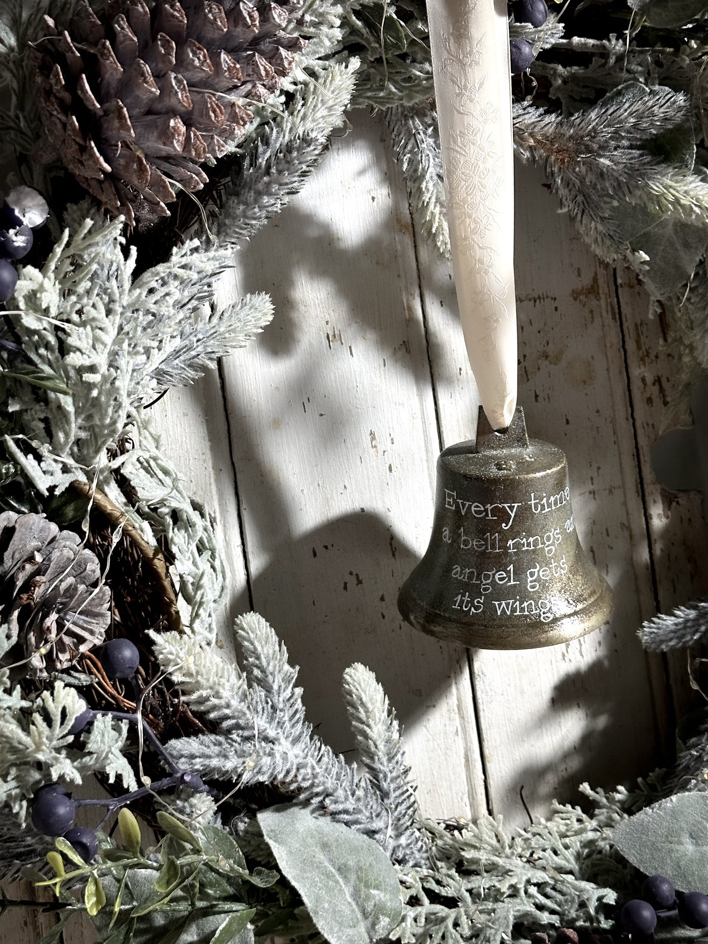 A vintage brass bell with a hand painted quote