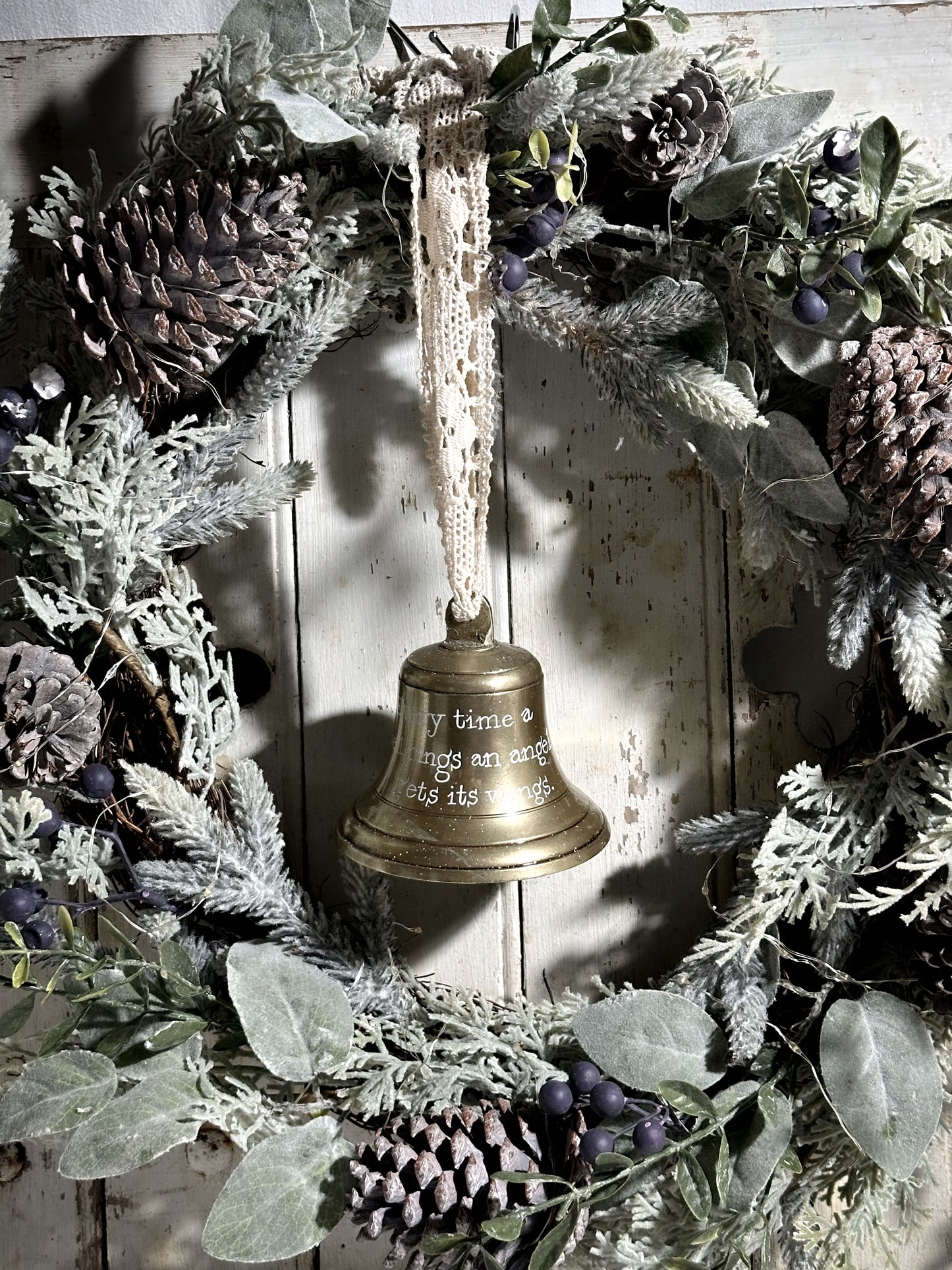 A vintage brass bell with a hand painted quote