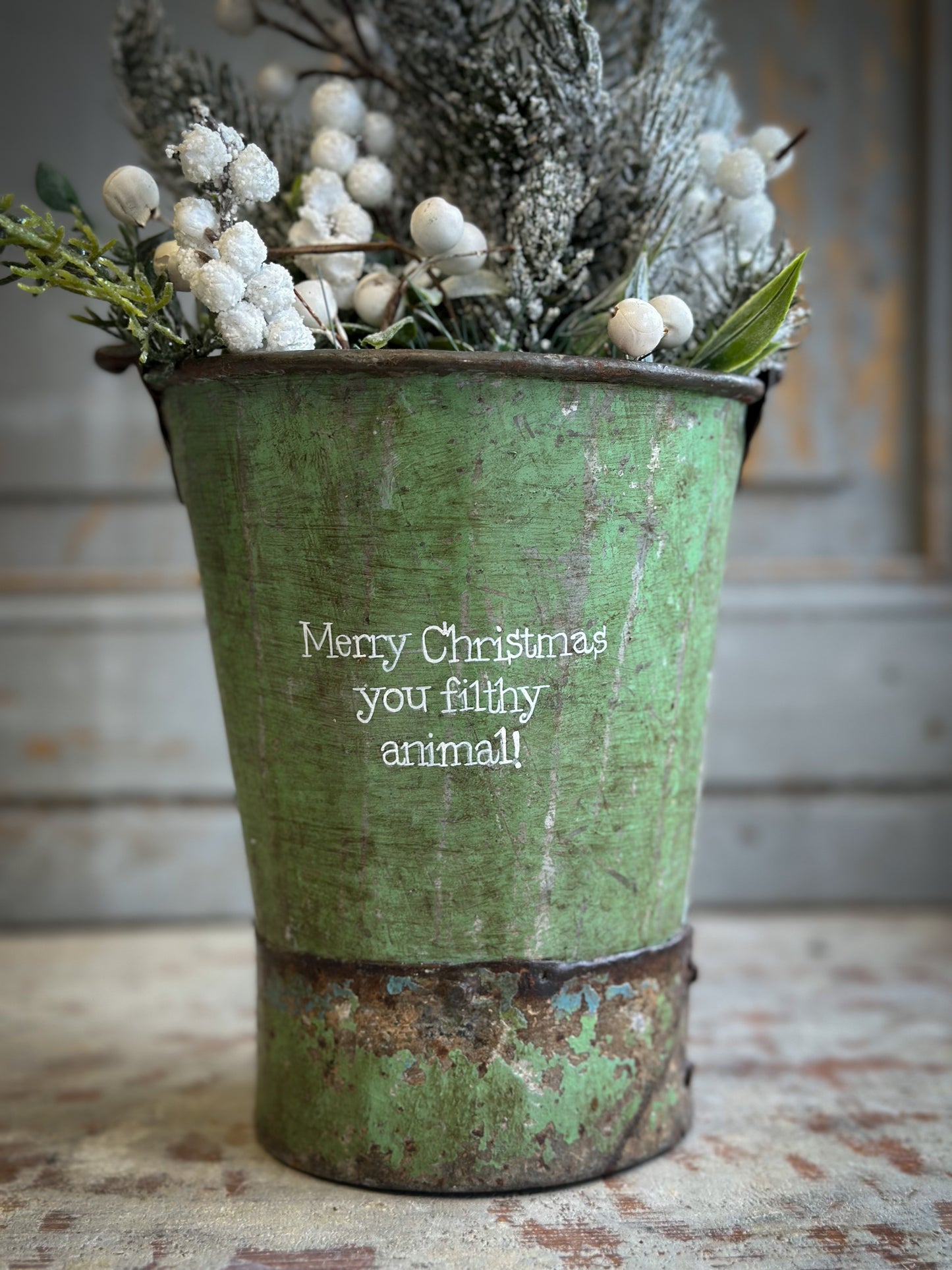 A Recycled Metal Mini Christmas Tree Bucket With A Hand Painted Quote