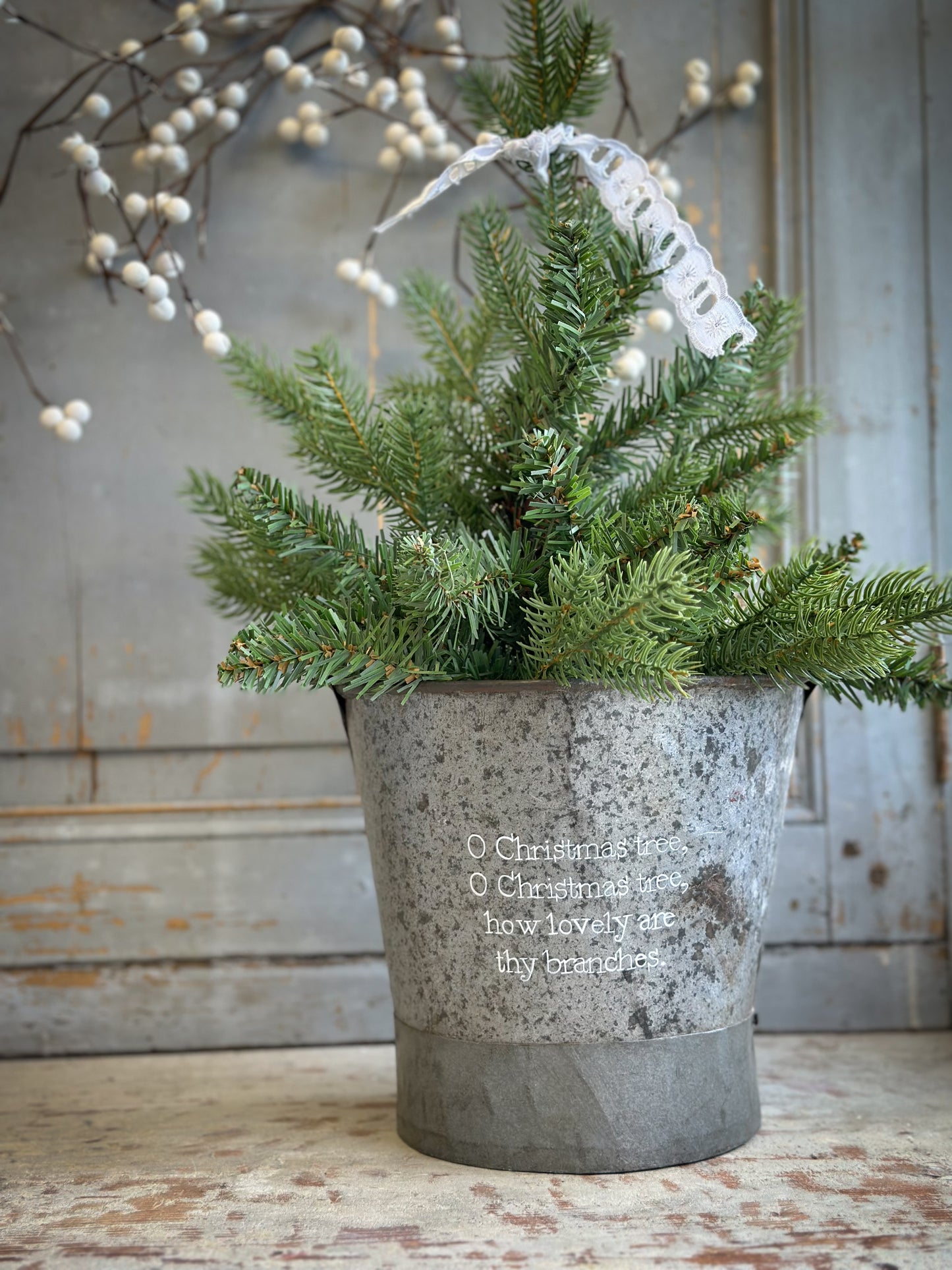 A Recycled Metal Small Christmas Tree Bucket With A Hand Painted Quote