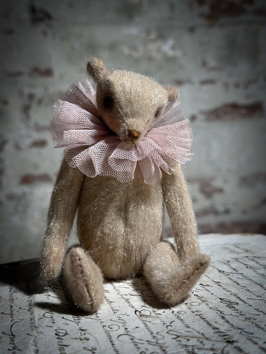 A beautiful hand made jointed collector’s teddy bear with antique pink tulle ruffle