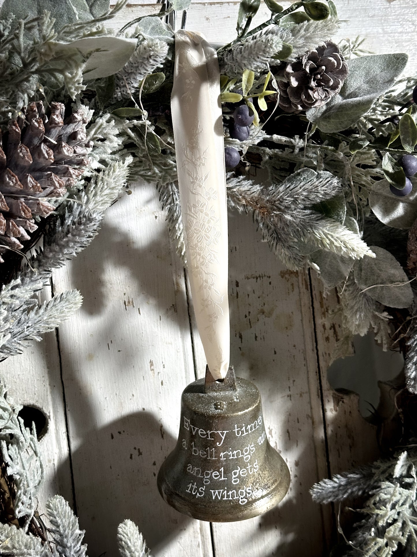 A vintage brass bell with a hand painted quote