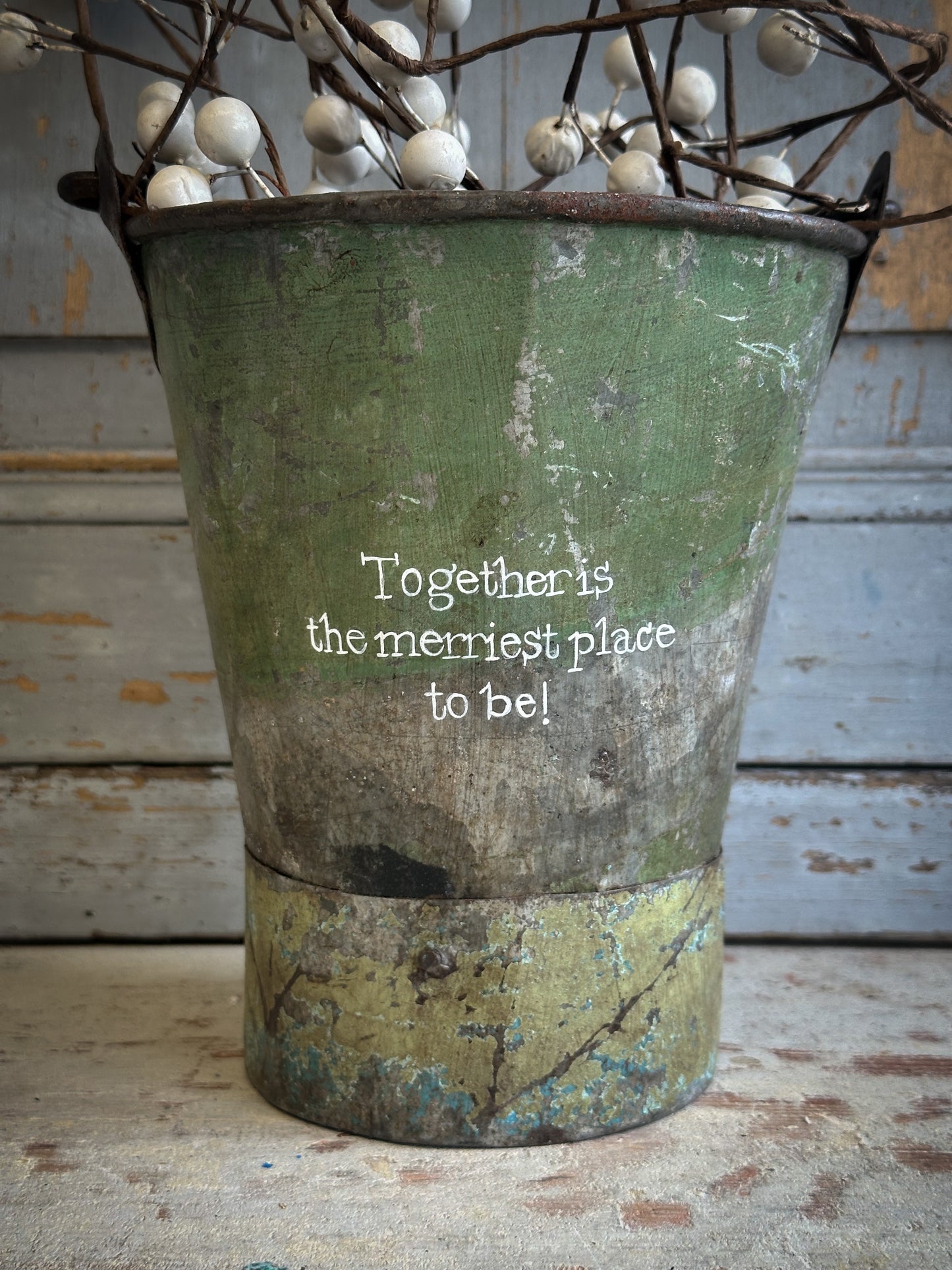 A Recycled Metal Mini Christmas Tree Bucket With A Hand Painted Quote