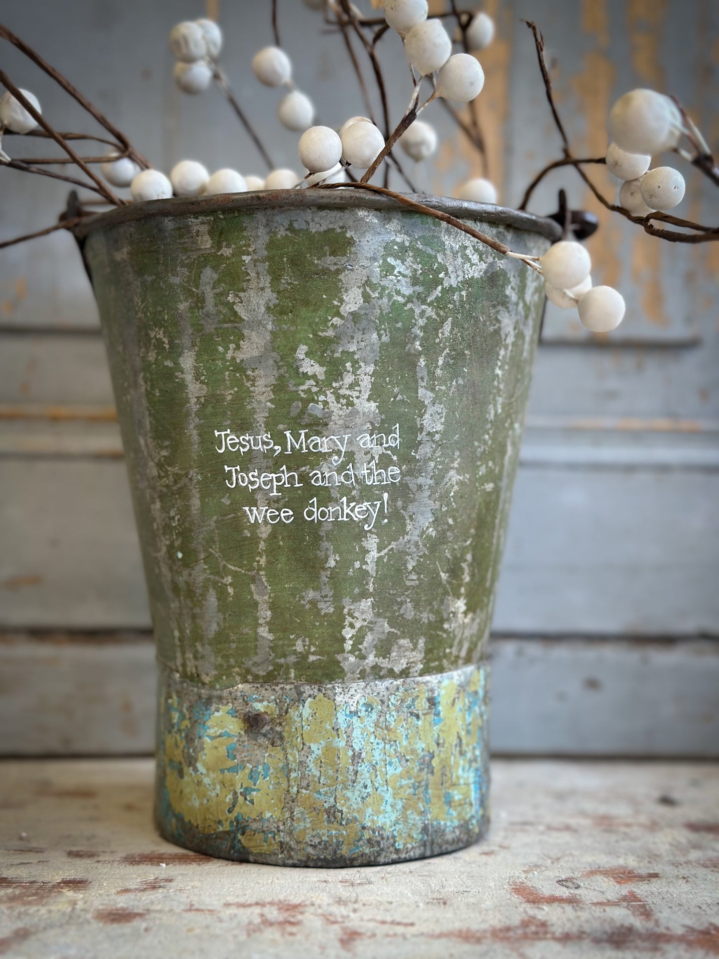 A Recycled Metal Mini Christmas Tree Bucket With A Hand Painted Quote