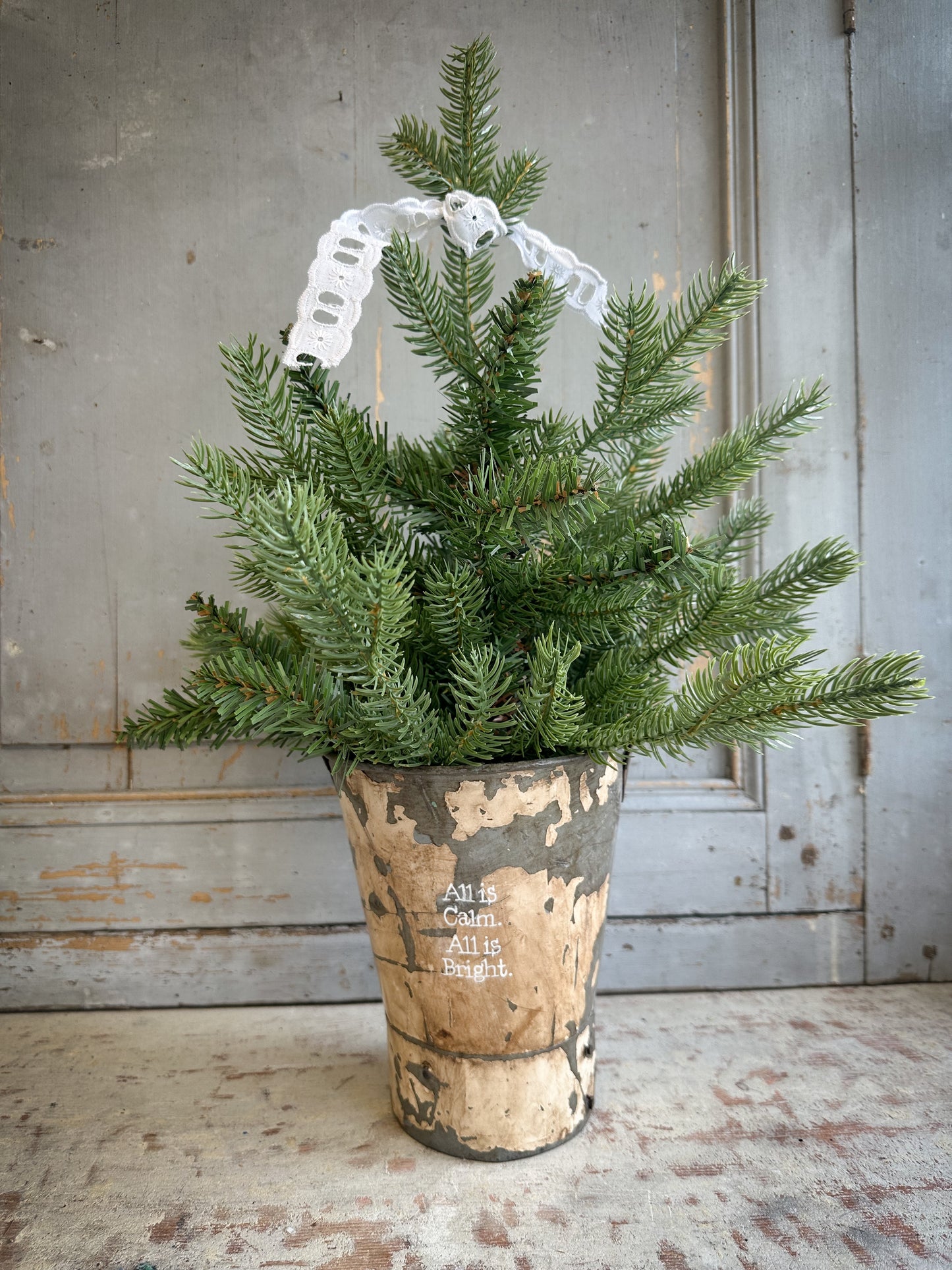A Recycled Metal Mini Christmas Tree Bucket With A Hand Painted Quote