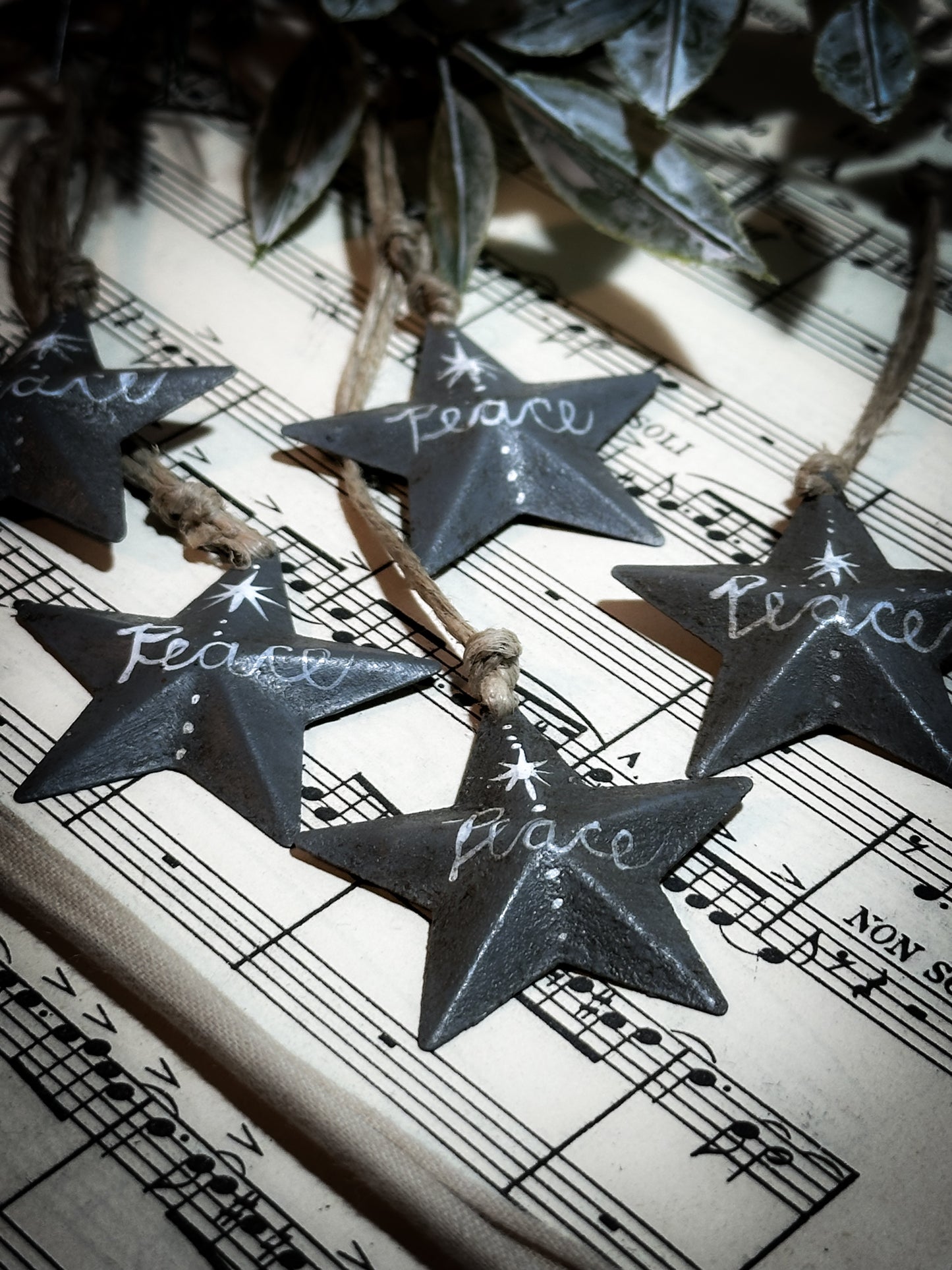 A mini tin barn star charcoal grey decoration hand painted with “Peace”