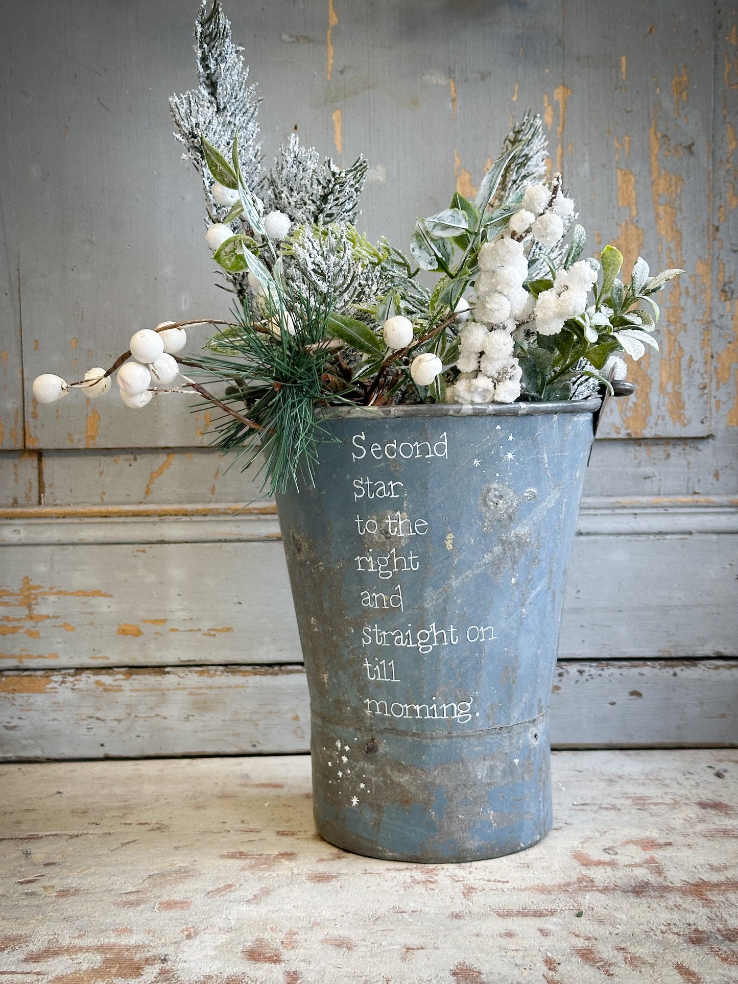 A Recycled Metal Mini Christmas Tree Bucket With A Hand Painted Quote