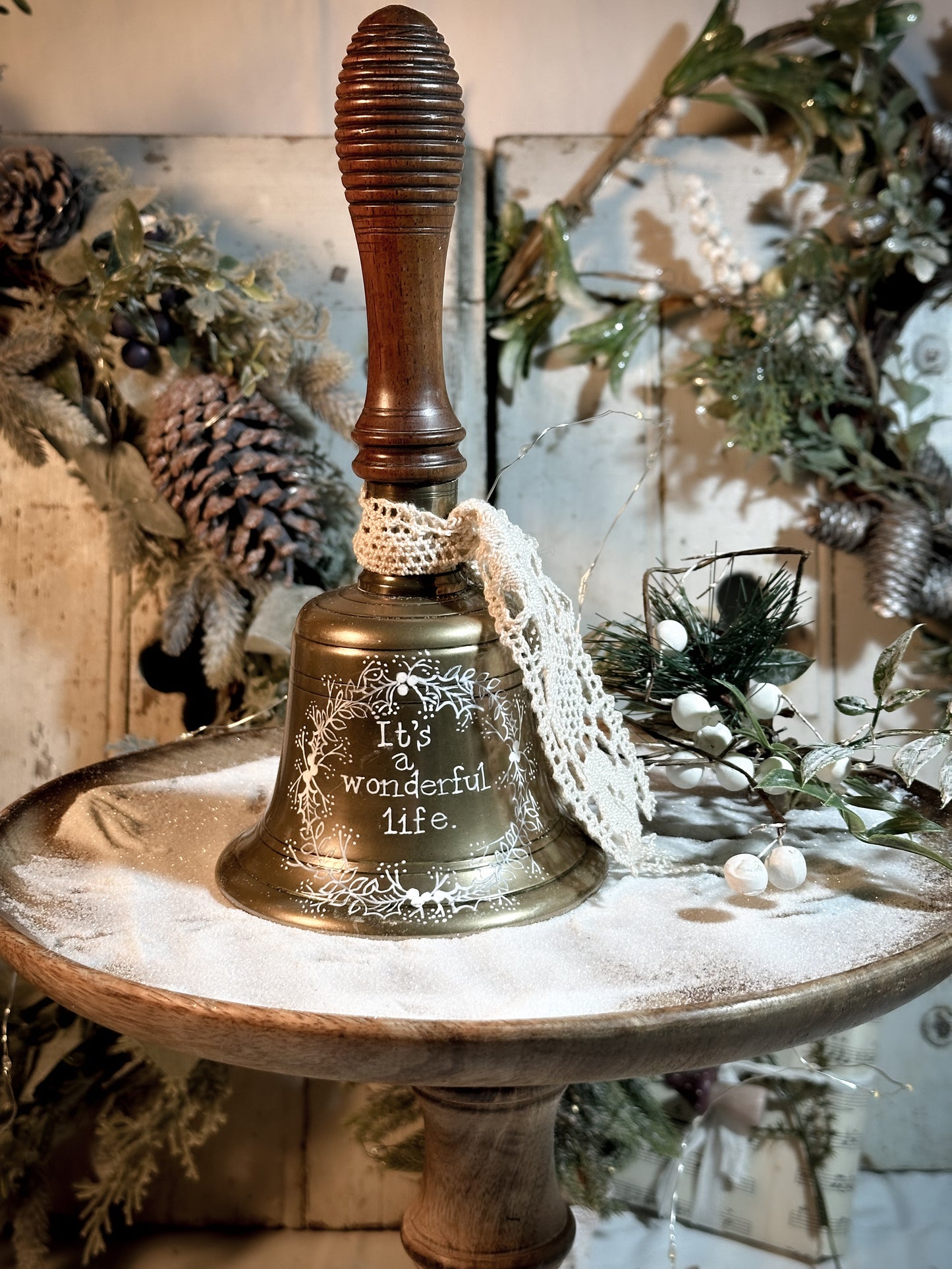 A vintage brass hand held bell with a hand painted quote