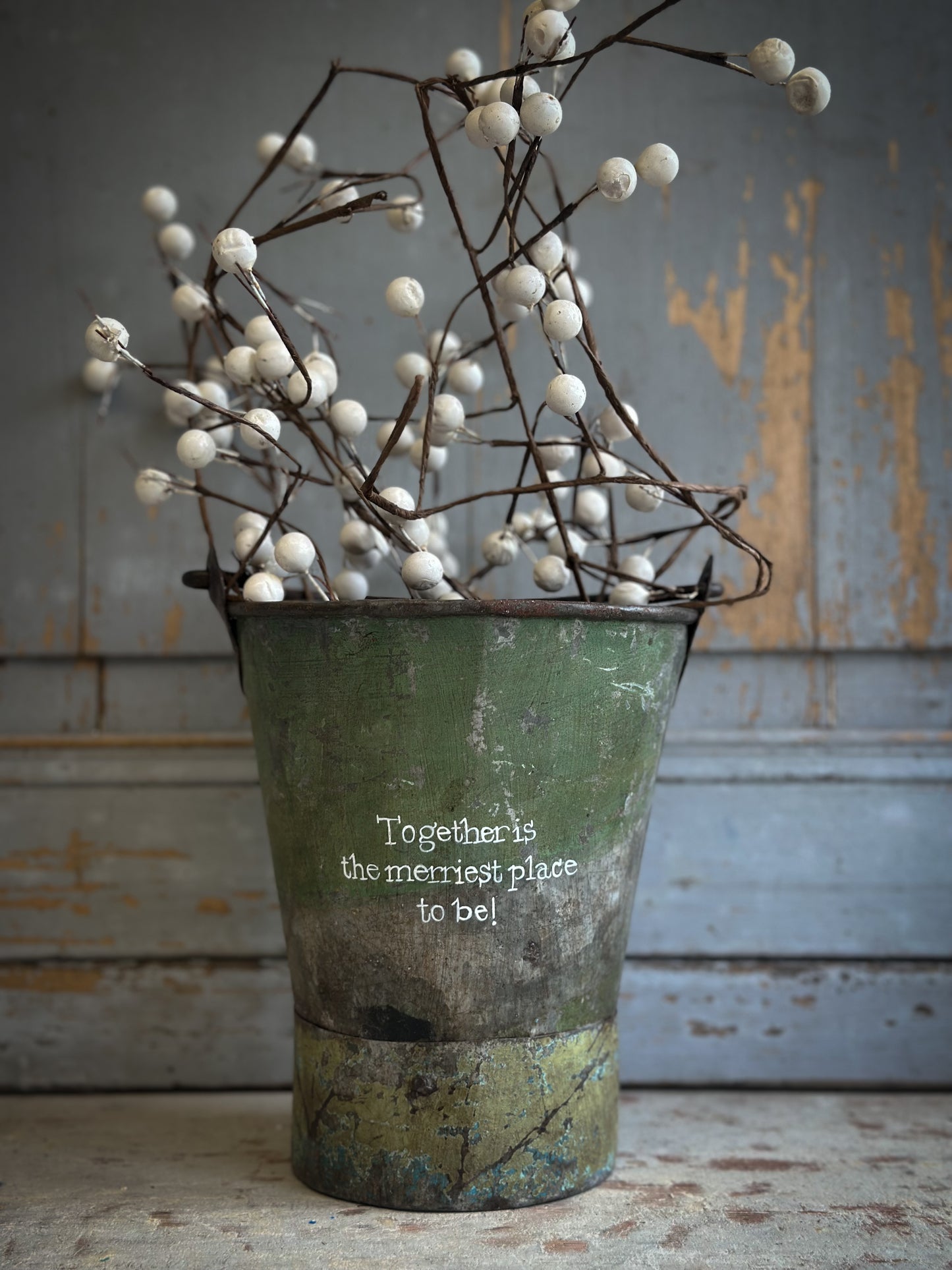 A Recycled Metal Mini Christmas Tree Bucket With A Hand Painted Quote