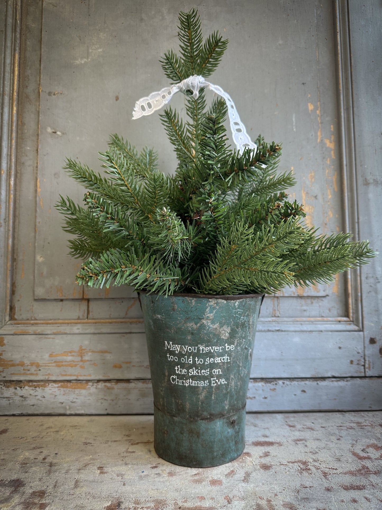 A Recycled Metal Mini Christmas Tree Bucket With A Hand Painted Quote