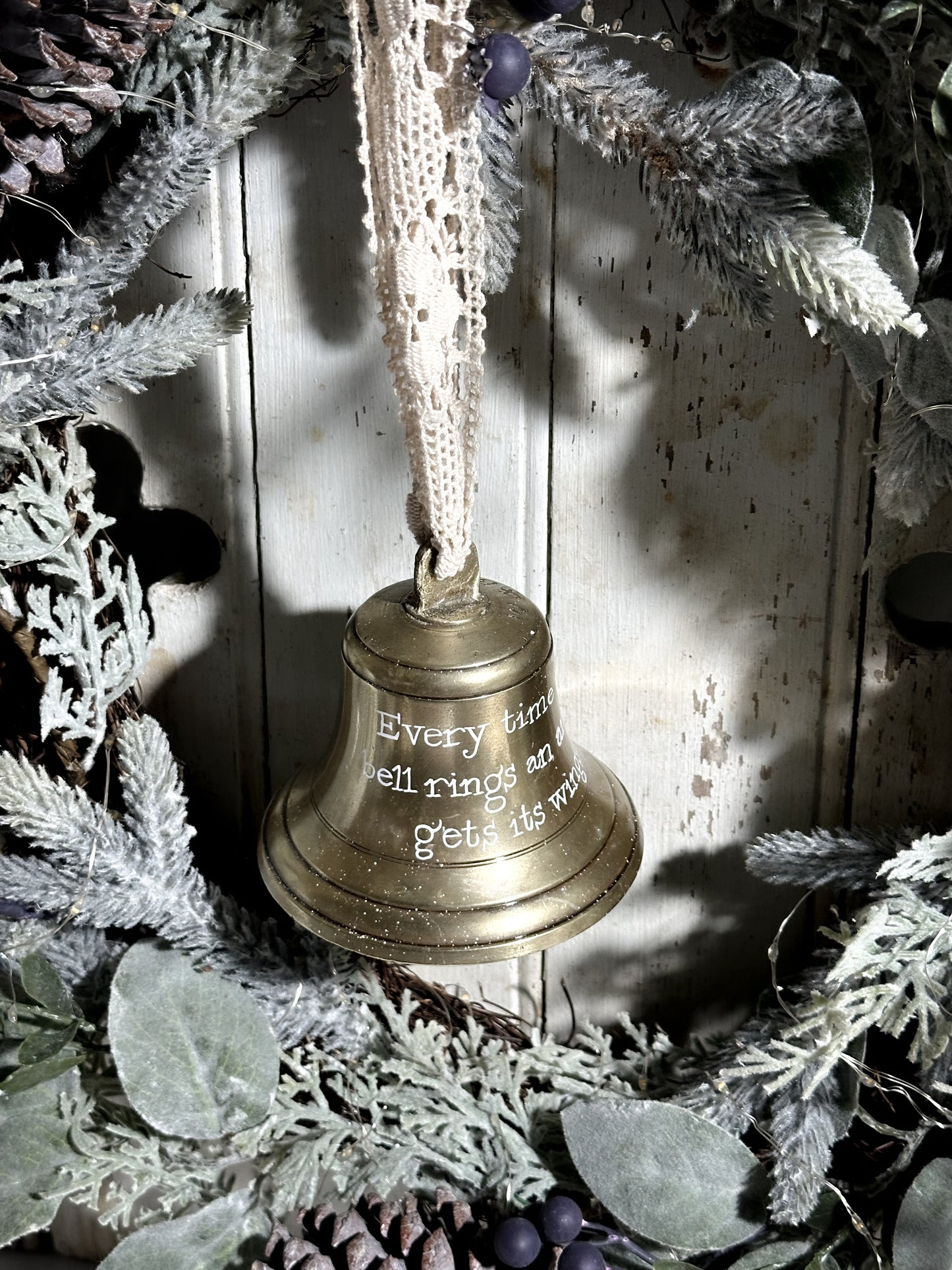 A vintage brass bell with a hand painted quote