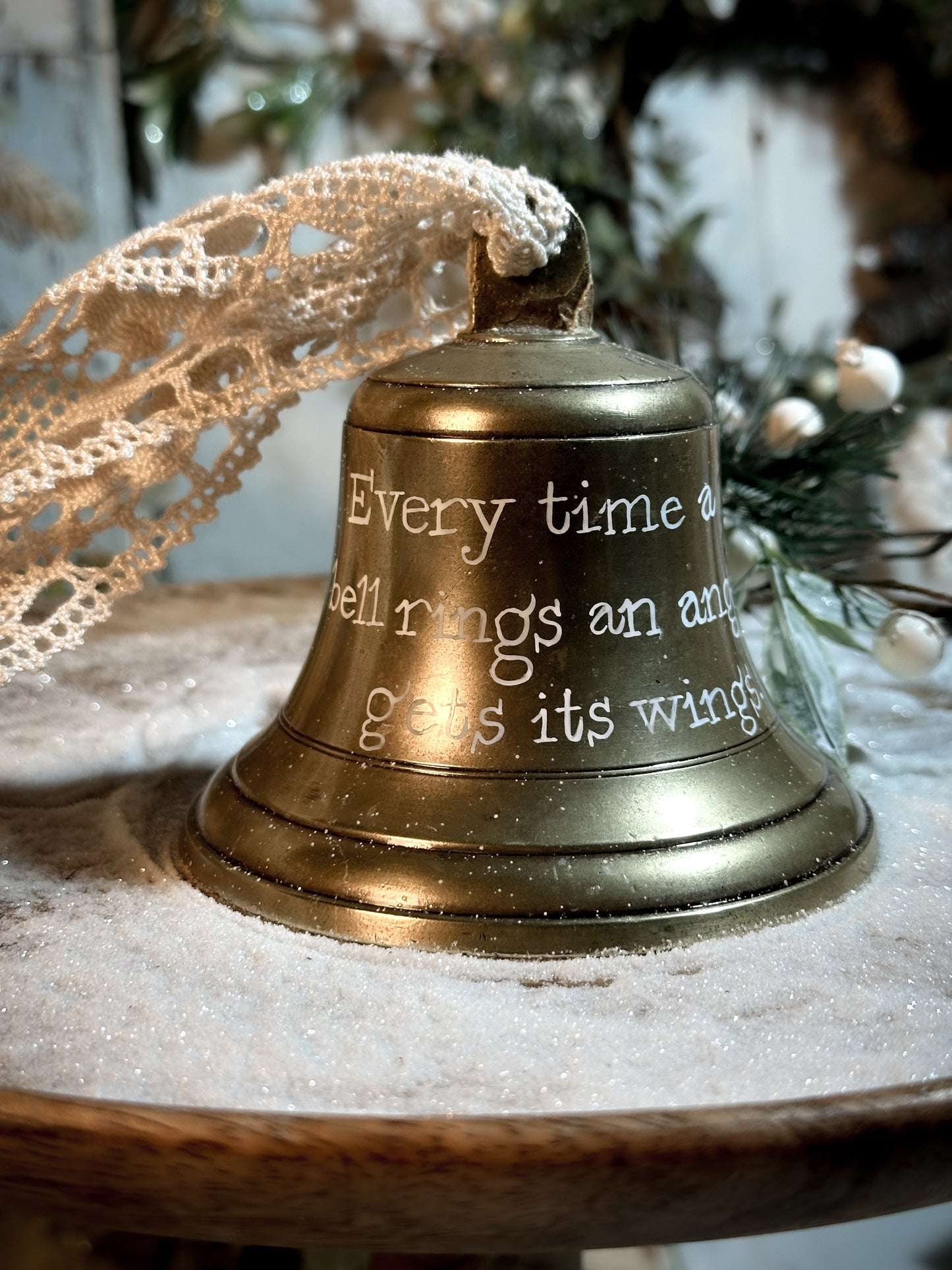 A vintage brass bell with a hand painted quote