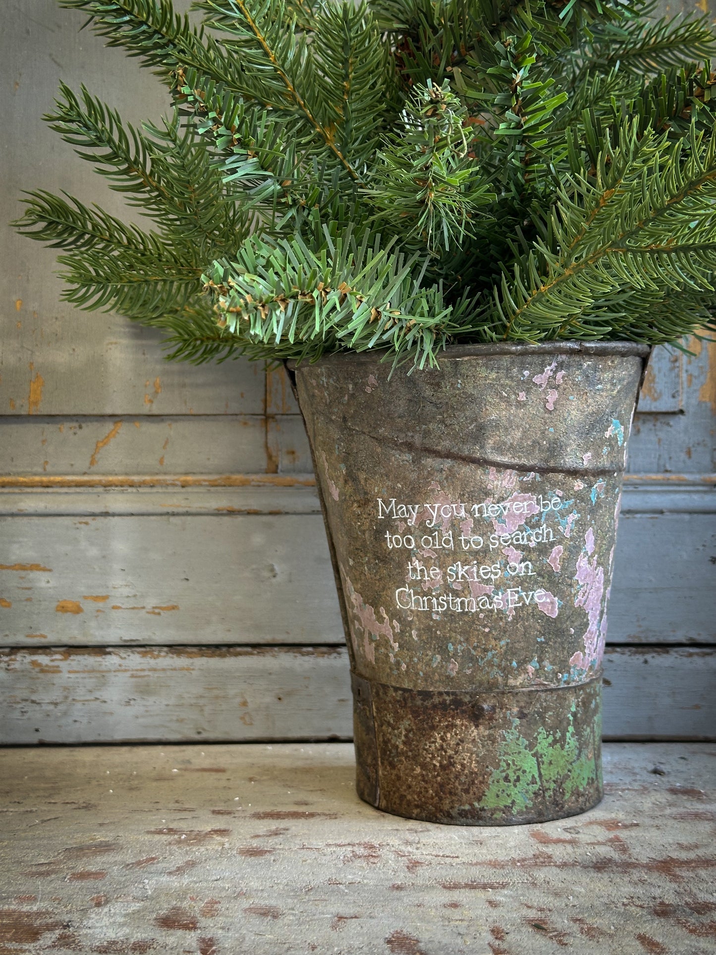 A Recycled Metal Mini Christmas Tree Bucket With A Hand Painted Quote