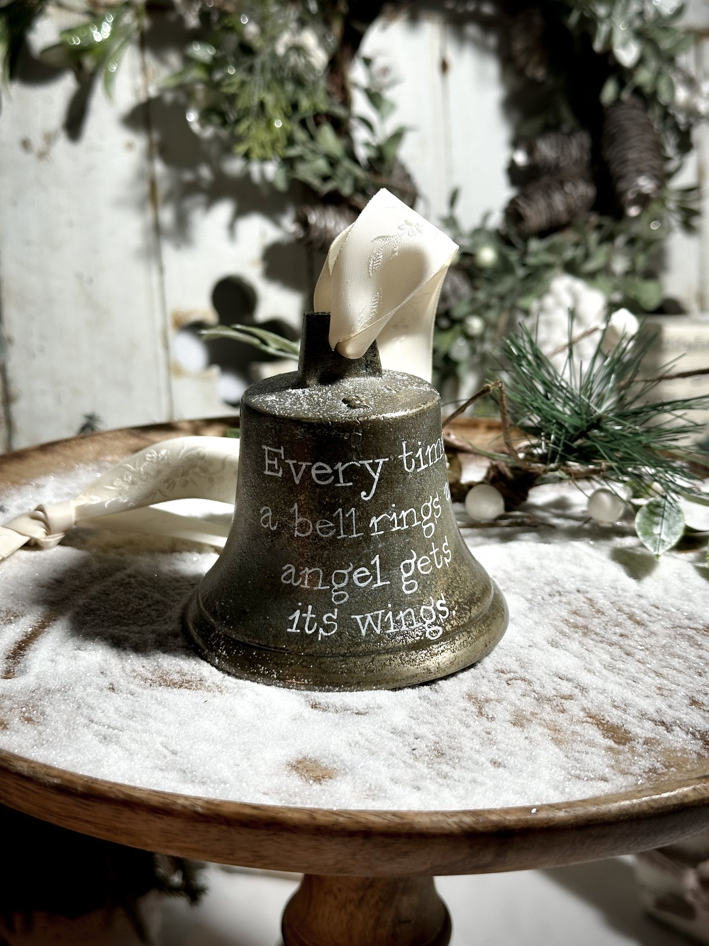 A vintage brass bell with a hand painted quote