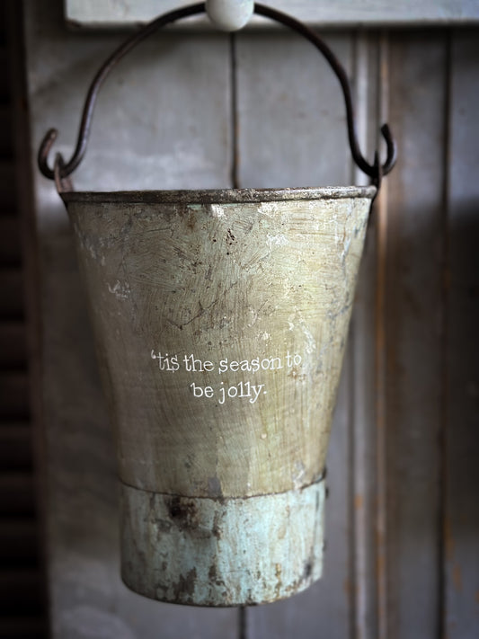 A Recycled Metal Mini Christmas Tree Bucket With A Hand Painted Quote