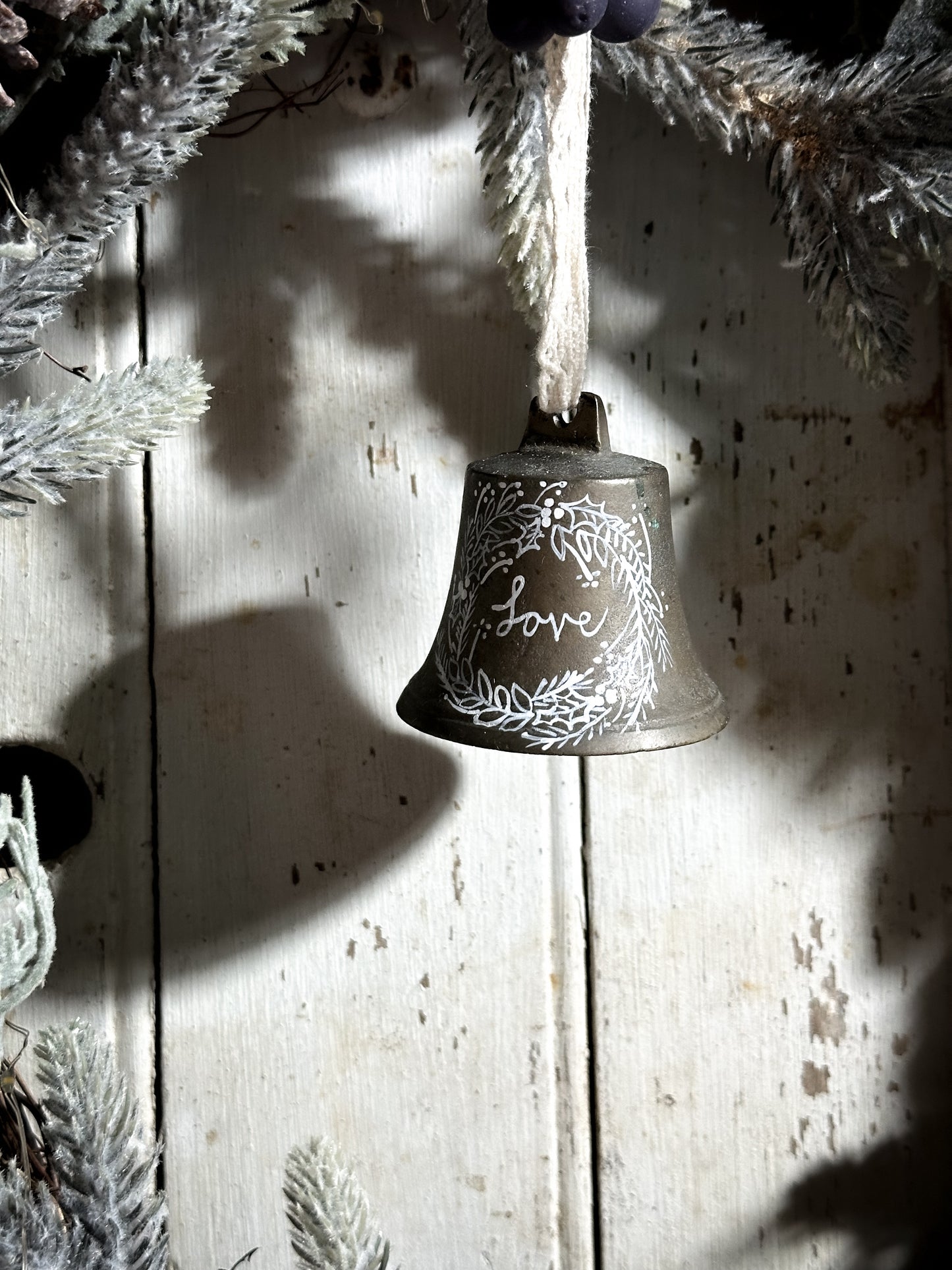 A vintage brass bell with a hand painted quote