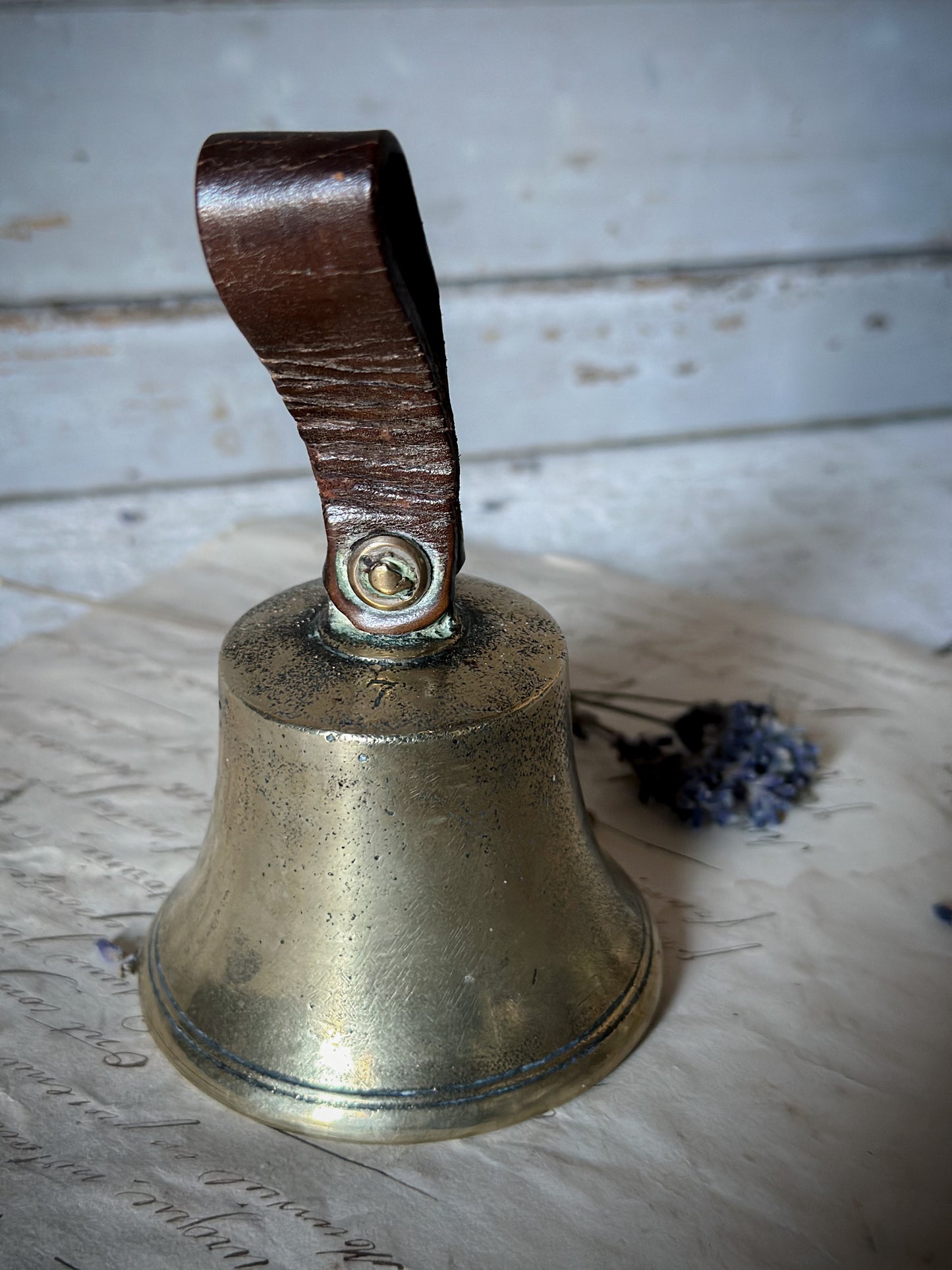 A beautiful antique brass bell with no.7, leather strap and iron clanger