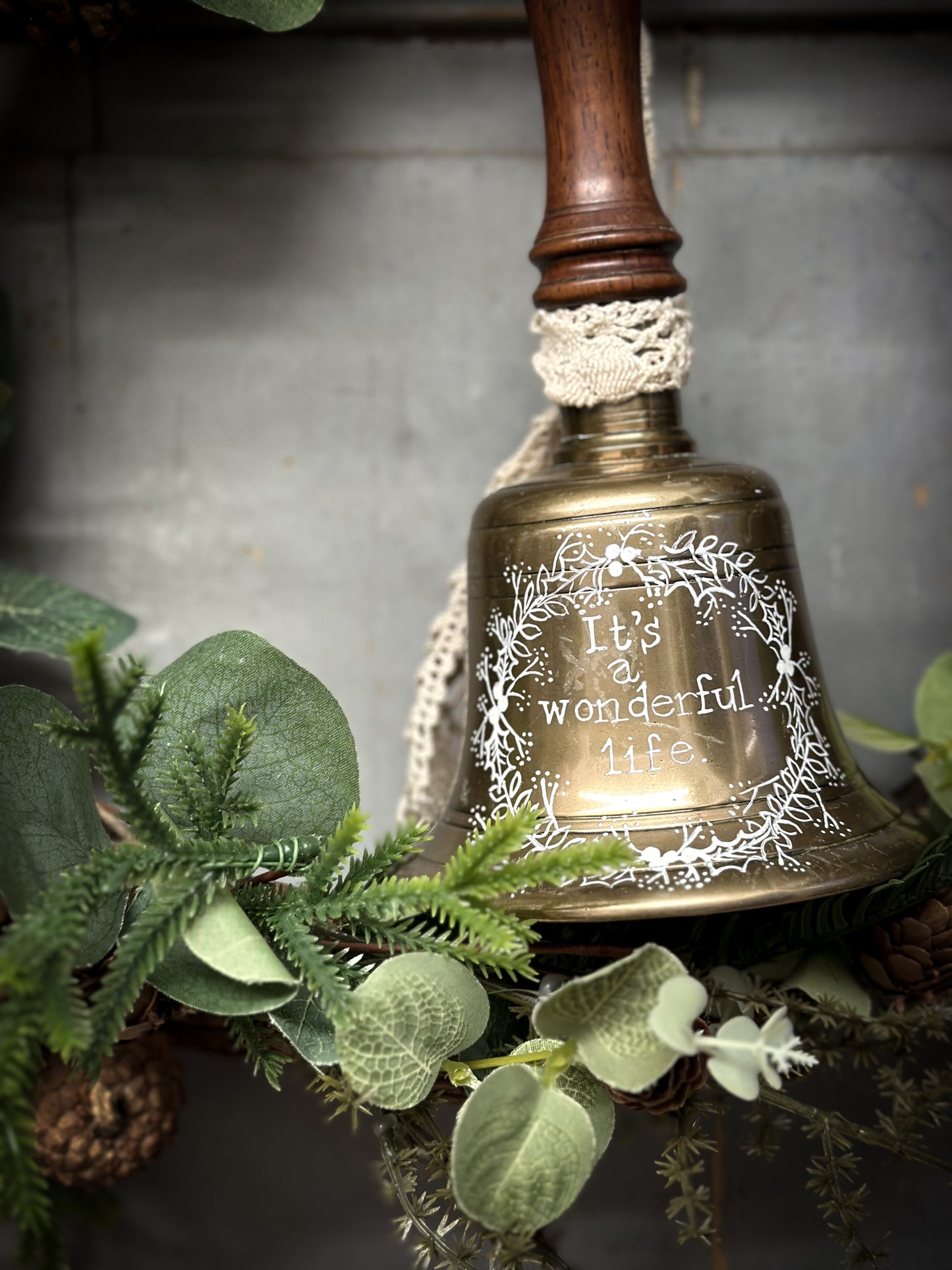 A vintage brass hand held bell with a hand painted quote