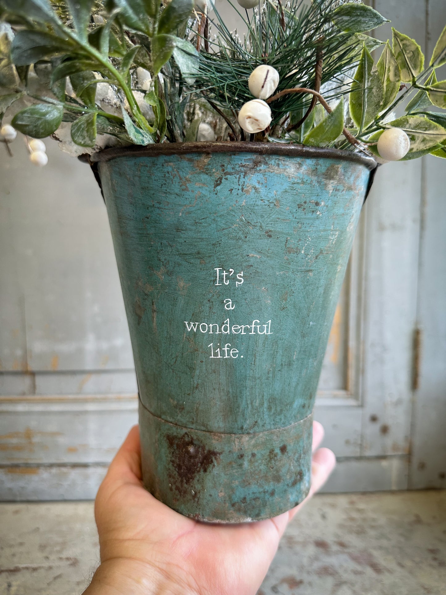 A Recycled Metal Mini Christmas Tree Bucket With A Hand Painted Quote
