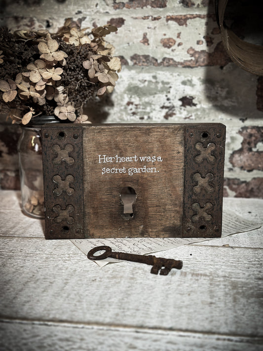 A salvaged original door lock with a painted quote