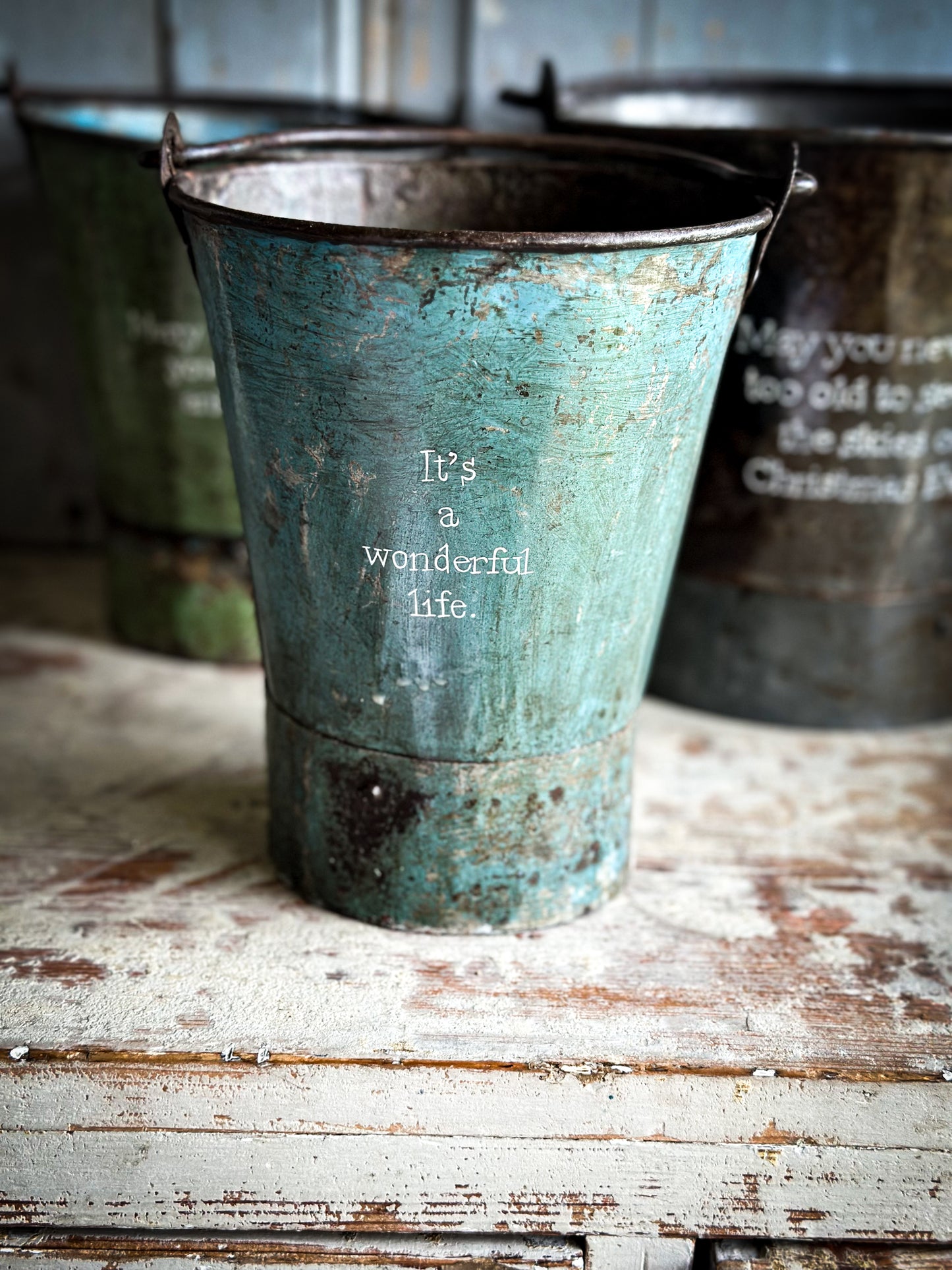 A Recycled Metal Mini Christmas Tree Bucket With A Hand Painted Quote