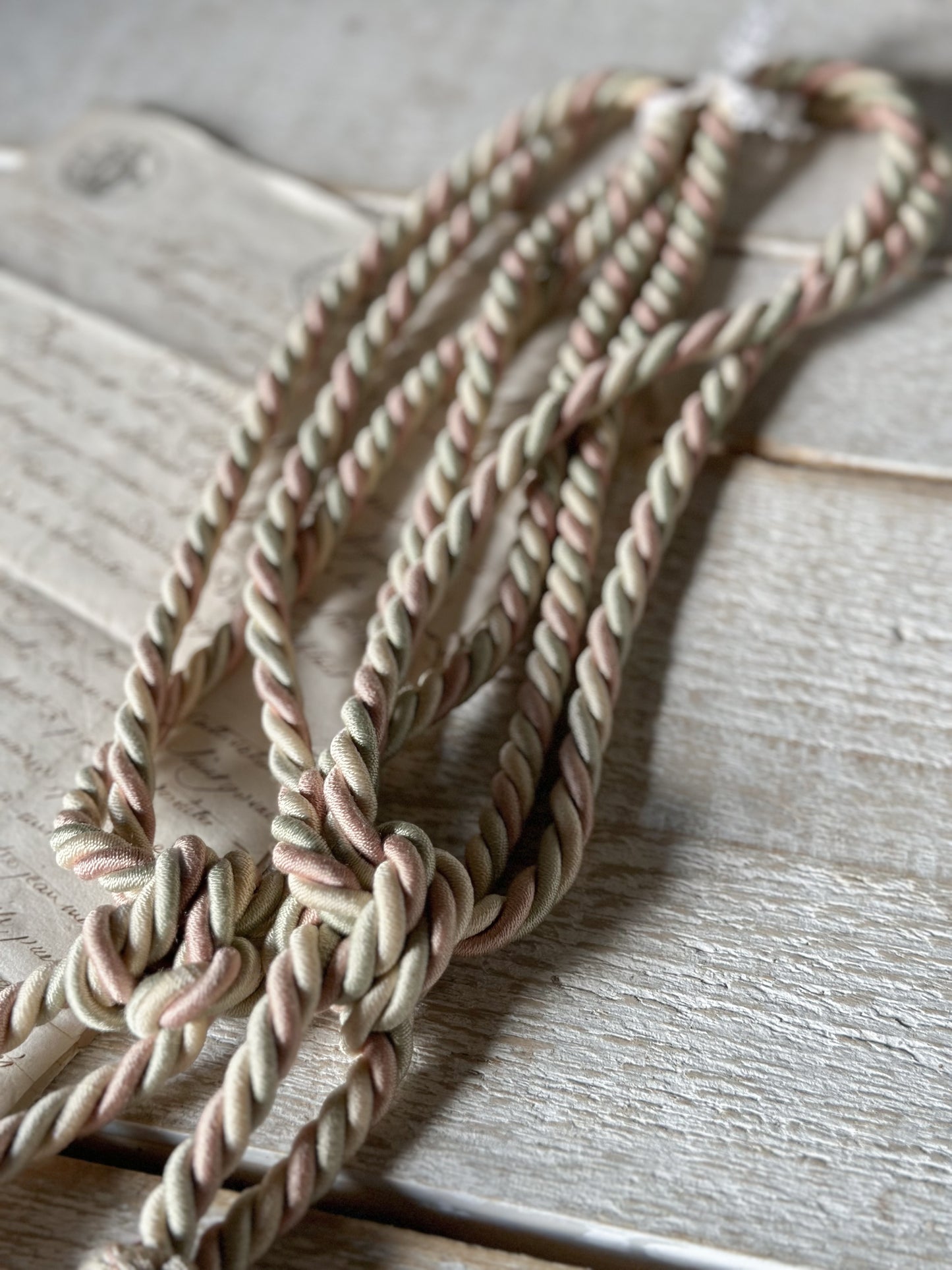 A pair of pretty vintage pastel pink, sage green and ivory curtain tie backs