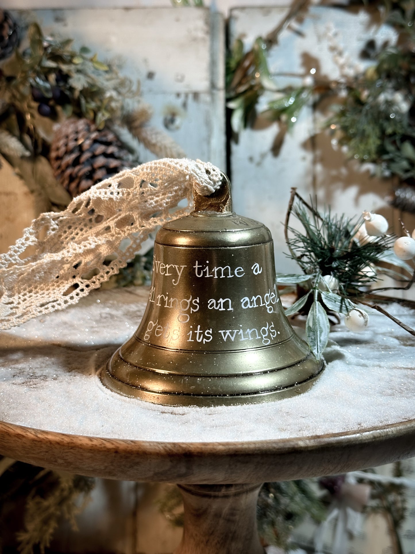 A vintage brass bell with a hand painted quote