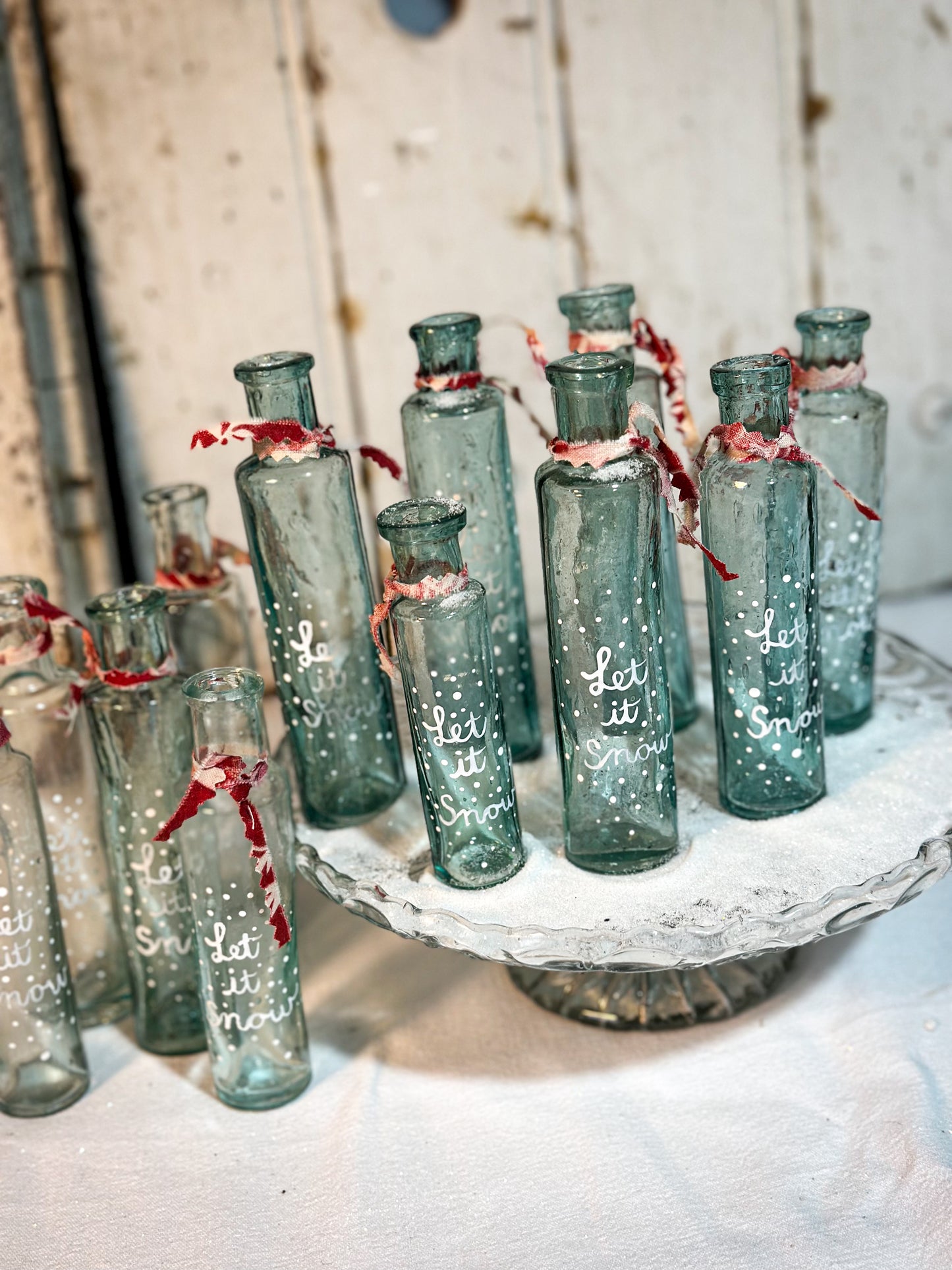 A beautiful Victorian cylinder bottle painted with a Christmas quote “Let it Snow”