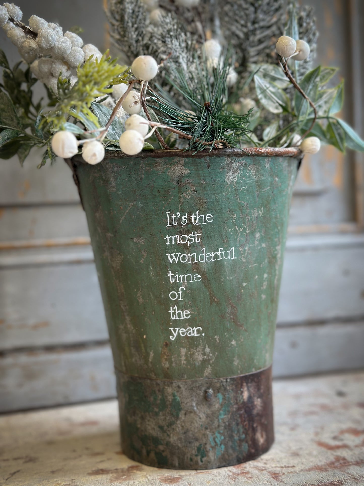 A Recycled Metal Mini Christmas Tree Bucket With A Hand Painted Quote