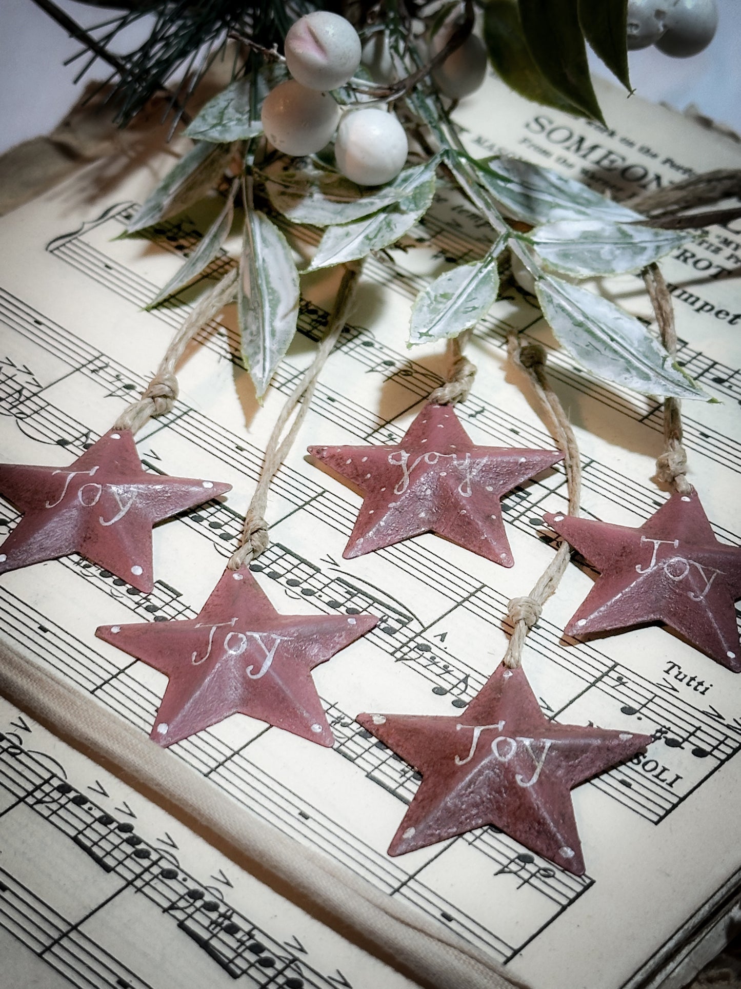 A mini tin barn star pink decoration hand painted with “Joy”