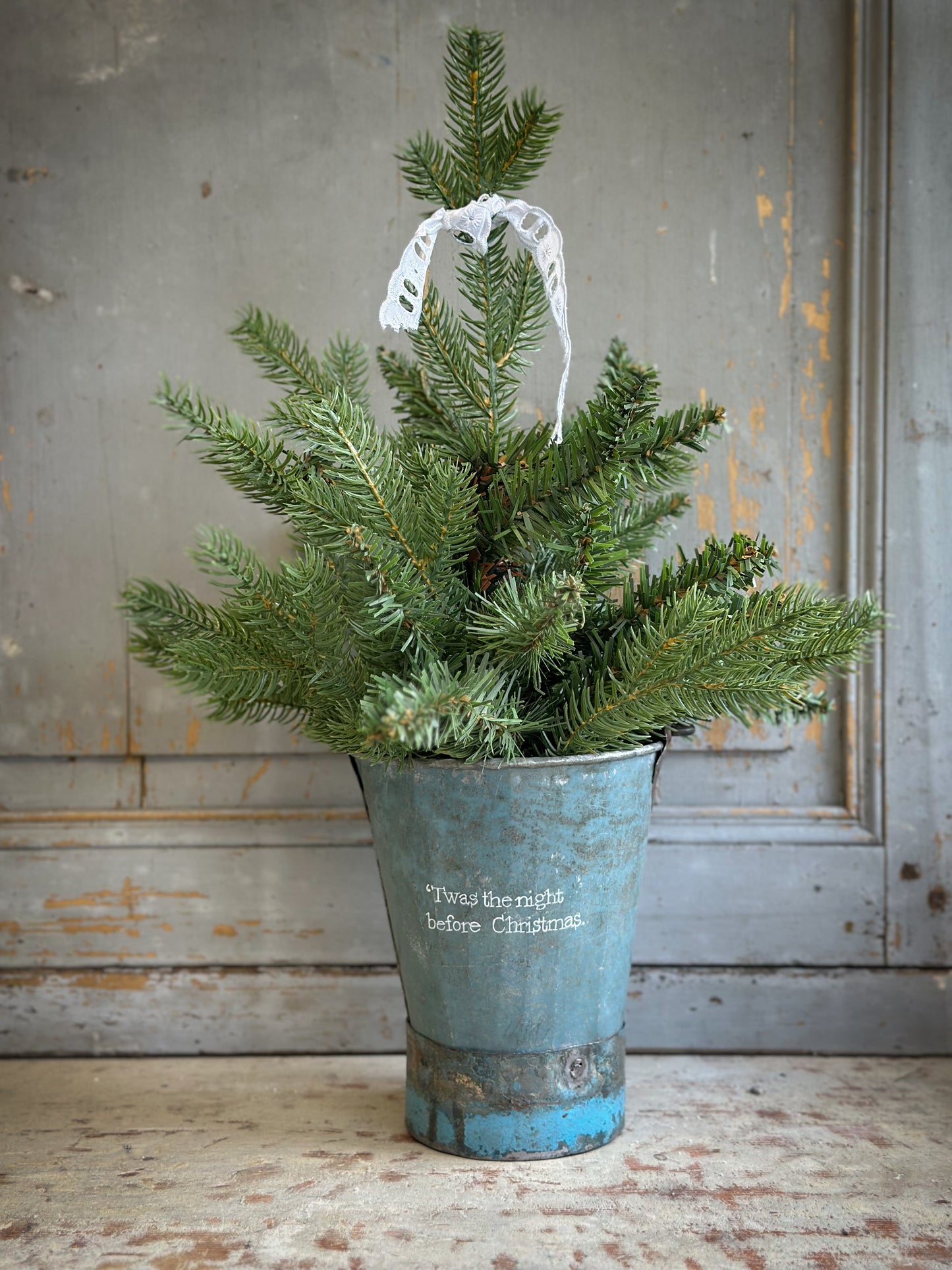 A Recycled Metal Mini Christmas Tree Bucket With A Hand Painted Quote