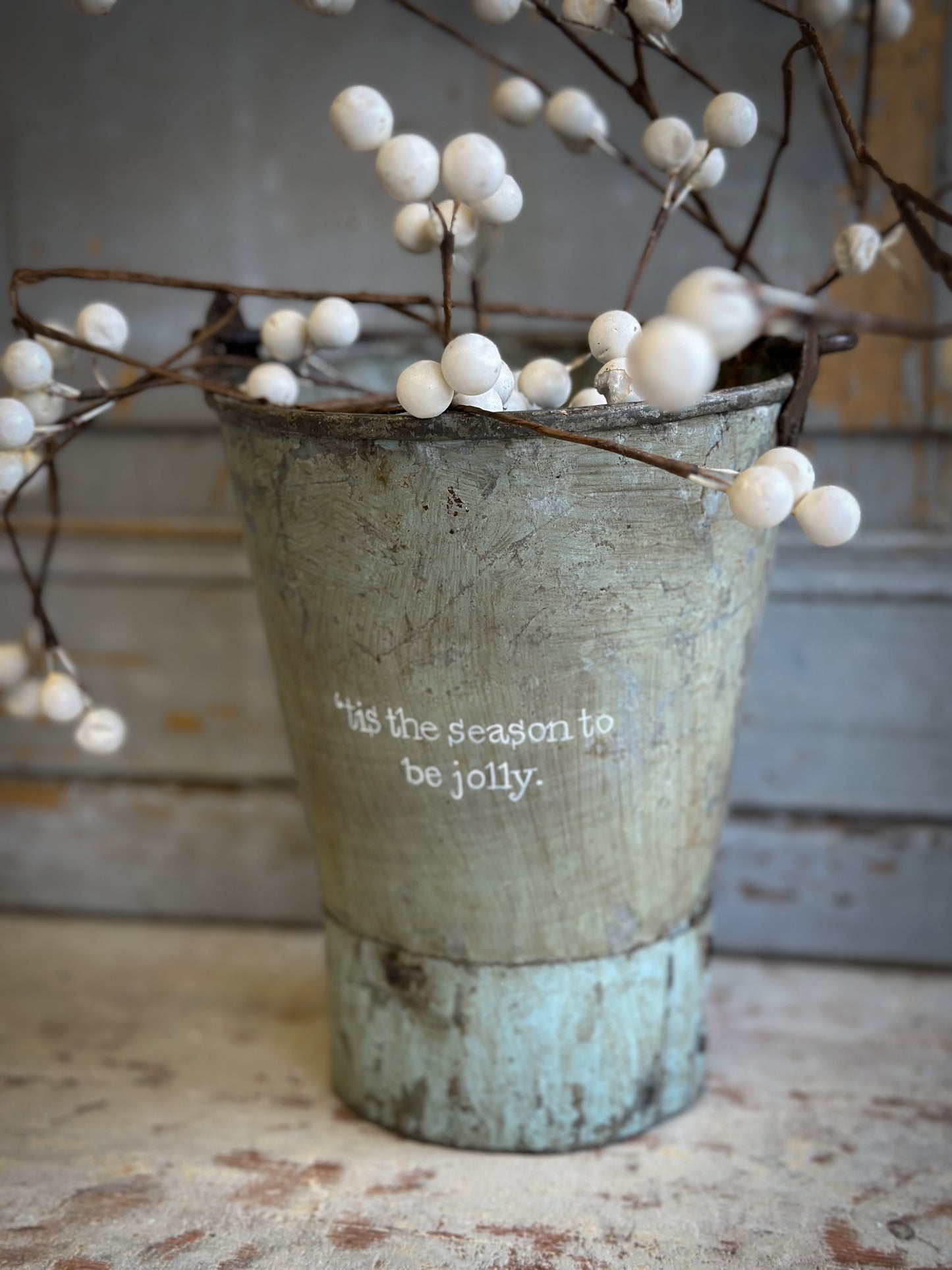 A Recycled Metal Mini Christmas Tree Bucket With A Hand Painted Quote