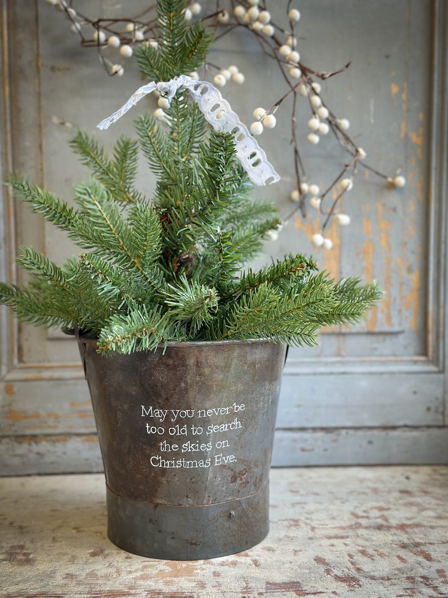 A Recycled Metal Small Christmas Tree Bucket With A Hand Painted Quote