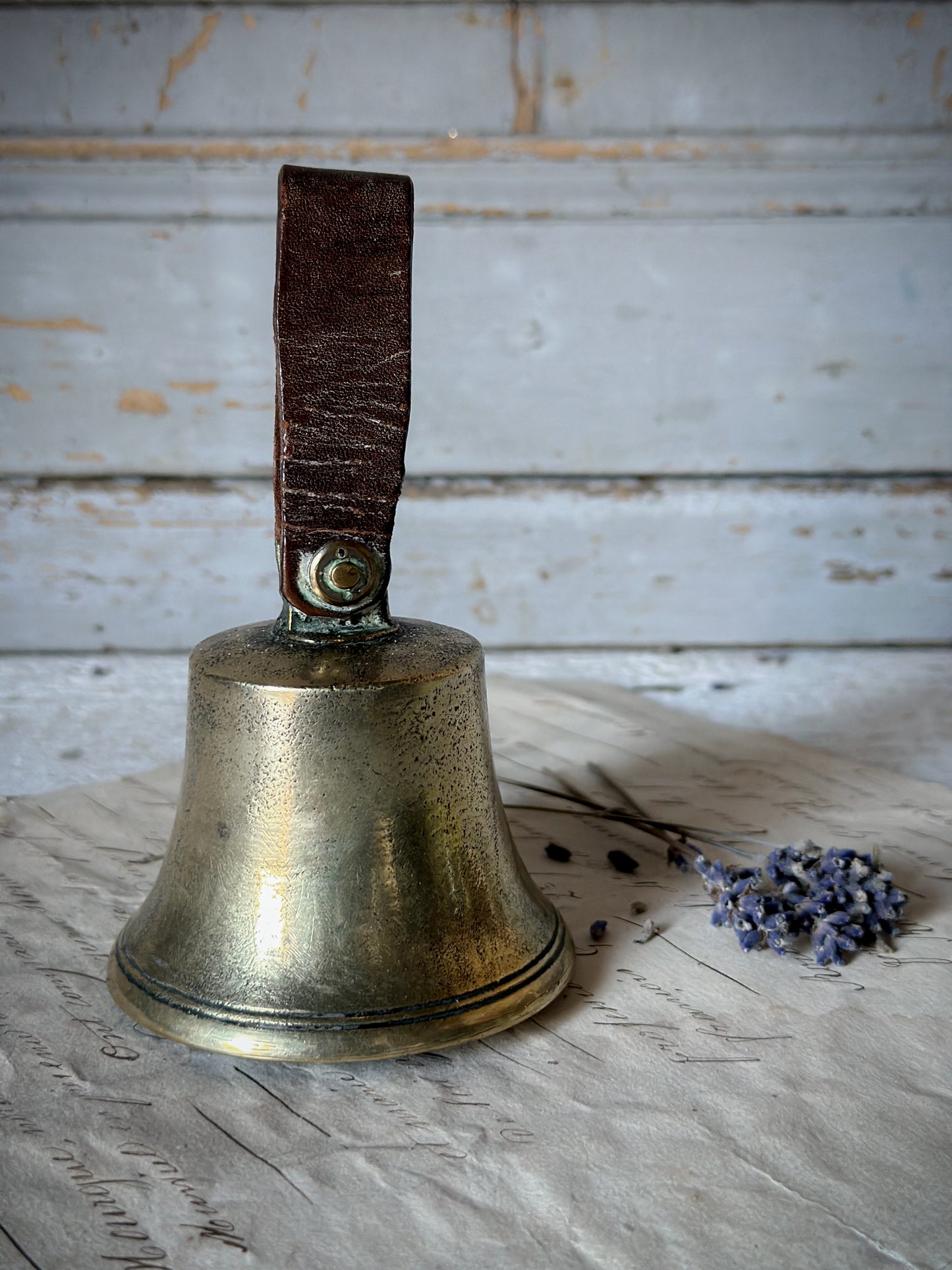 A beautiful antique brass bell with no.7, leather strap and iron clanger