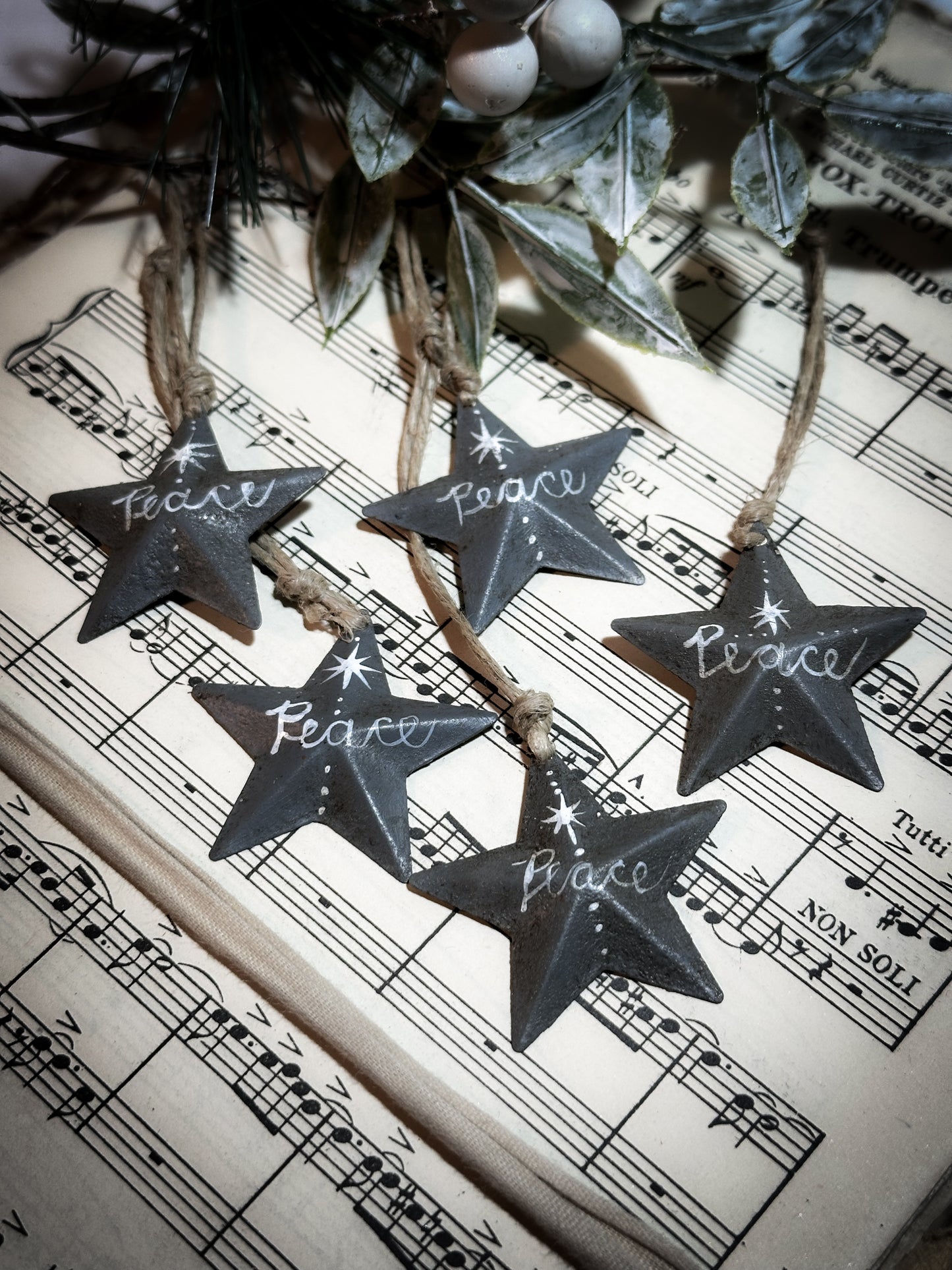 A mini tin barn star charcoal grey decoration hand painted with “Peace”