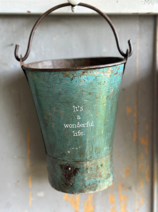 A Recycled Metal Mini Christmas Tree Bucket With A Hand Painted Quote