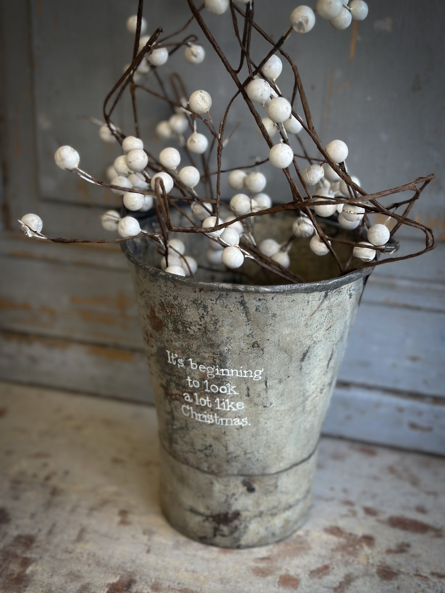 A Recycled Metal Mini Christmas Tree Bucket With A Hand Painted Quote