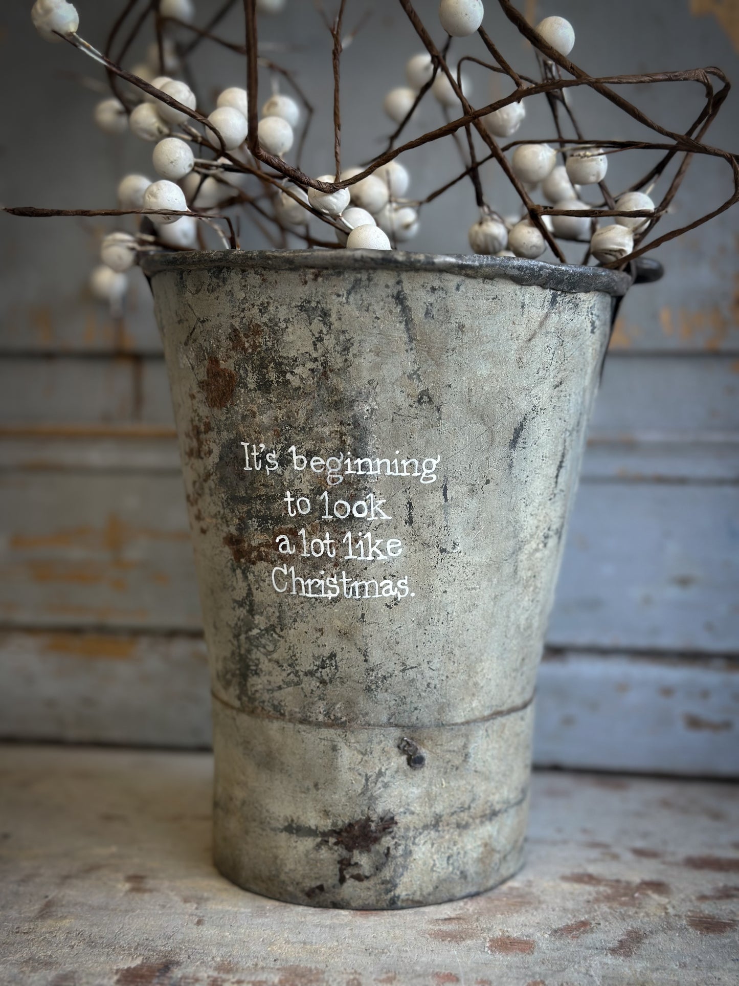 A Recycled Metal Mini Christmas Tree Bucket With A Hand Painted Quote
