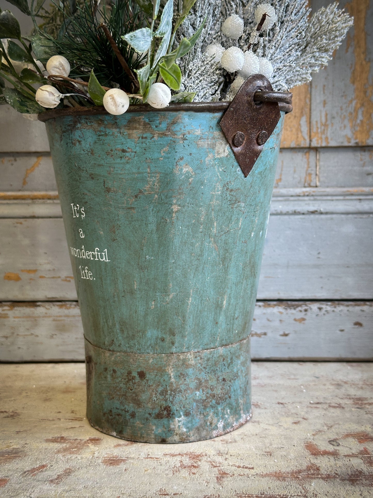 A Recycled Metal Mini Christmas Tree Bucket With A Hand Painted Quote